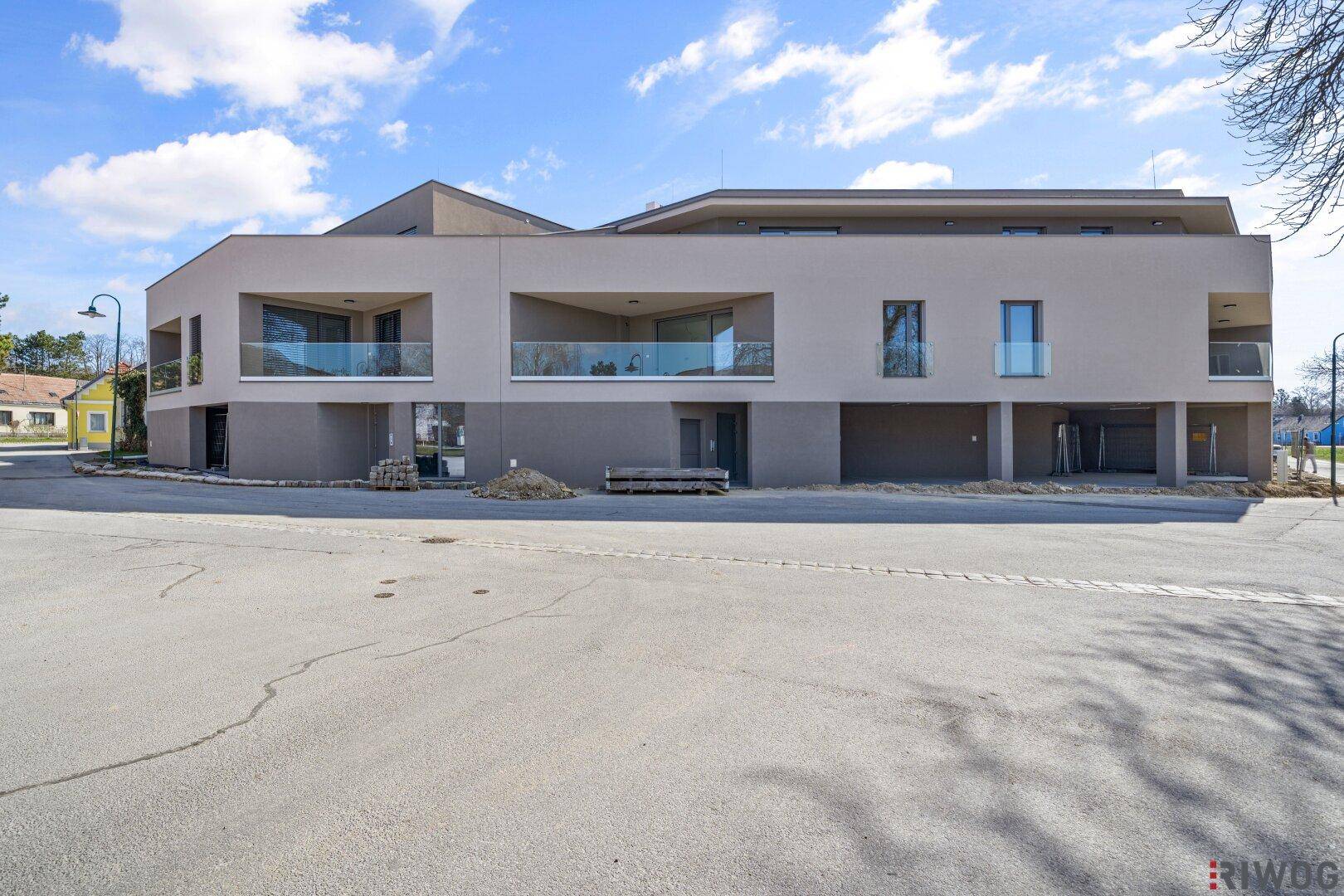 Moderne Wohnanlage mit mehreren Balkonen und großen Fenstern in zeitgemäßer Architektur.