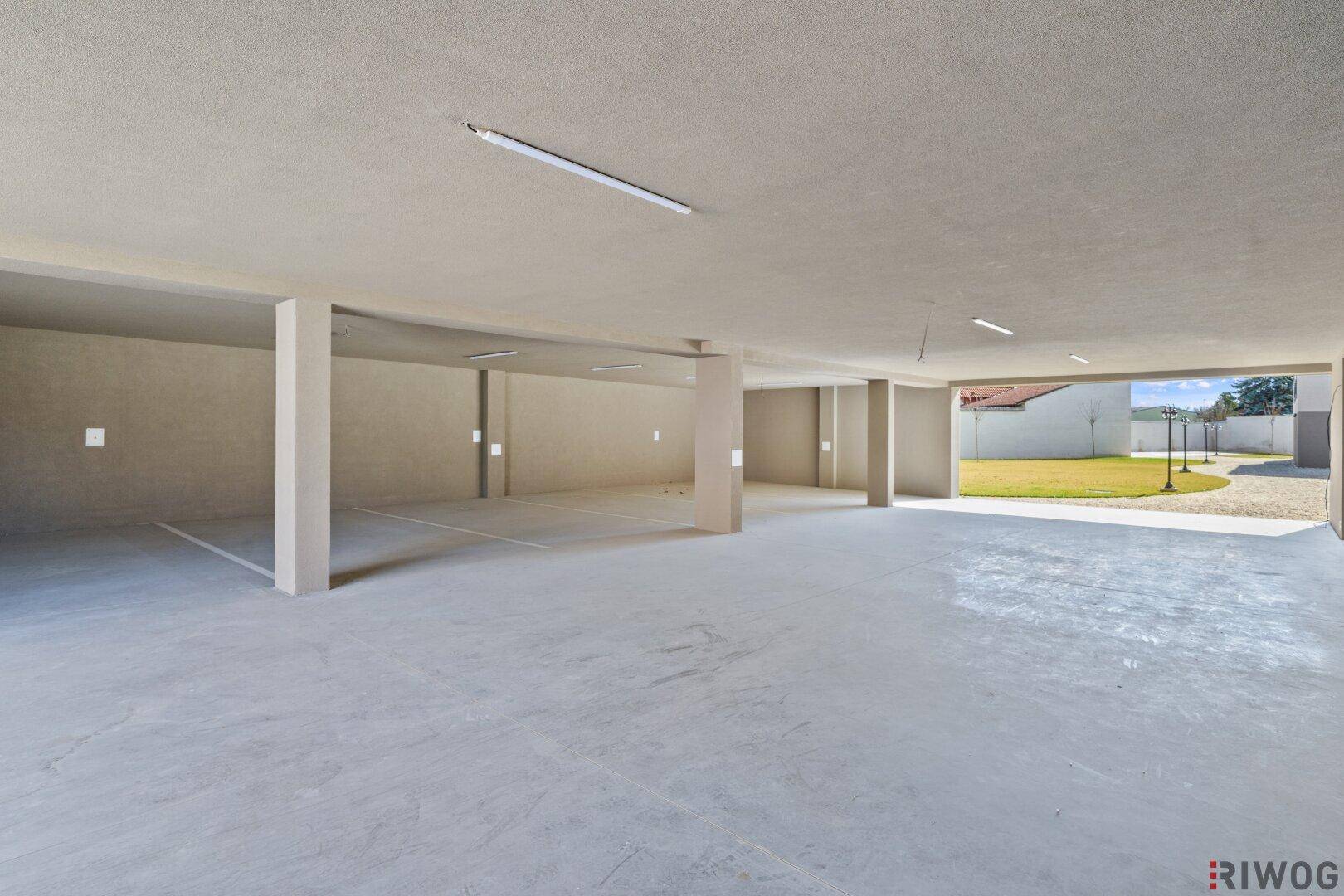 Geräumige Tiefgarage mit Betonboden und ausreichend Stellplätzen für Fahrzeuge.