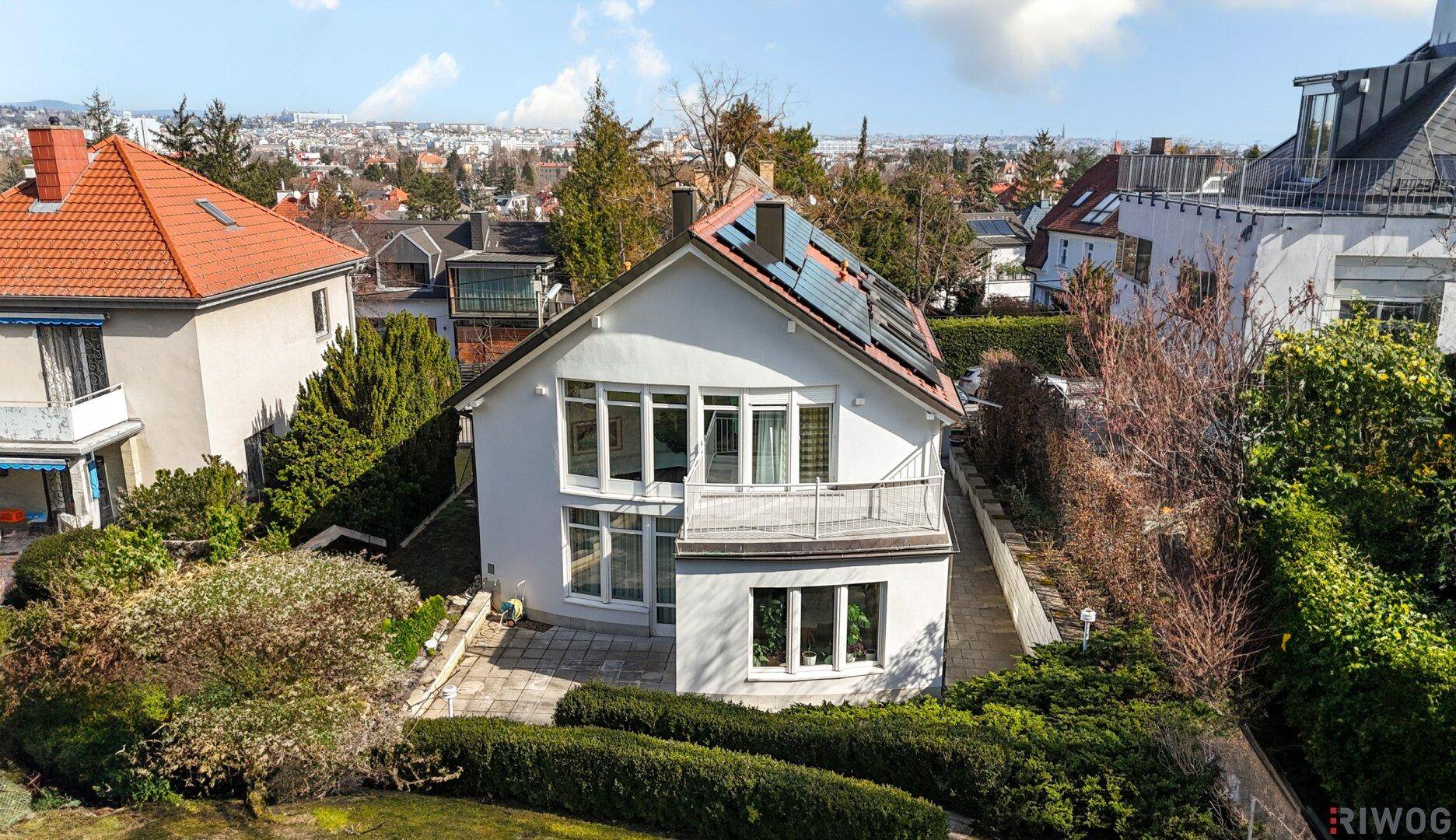 Vogelperspektive des Hauses mit Solarpaneelen auf dem Dach und umliegender Wohnbebauung.