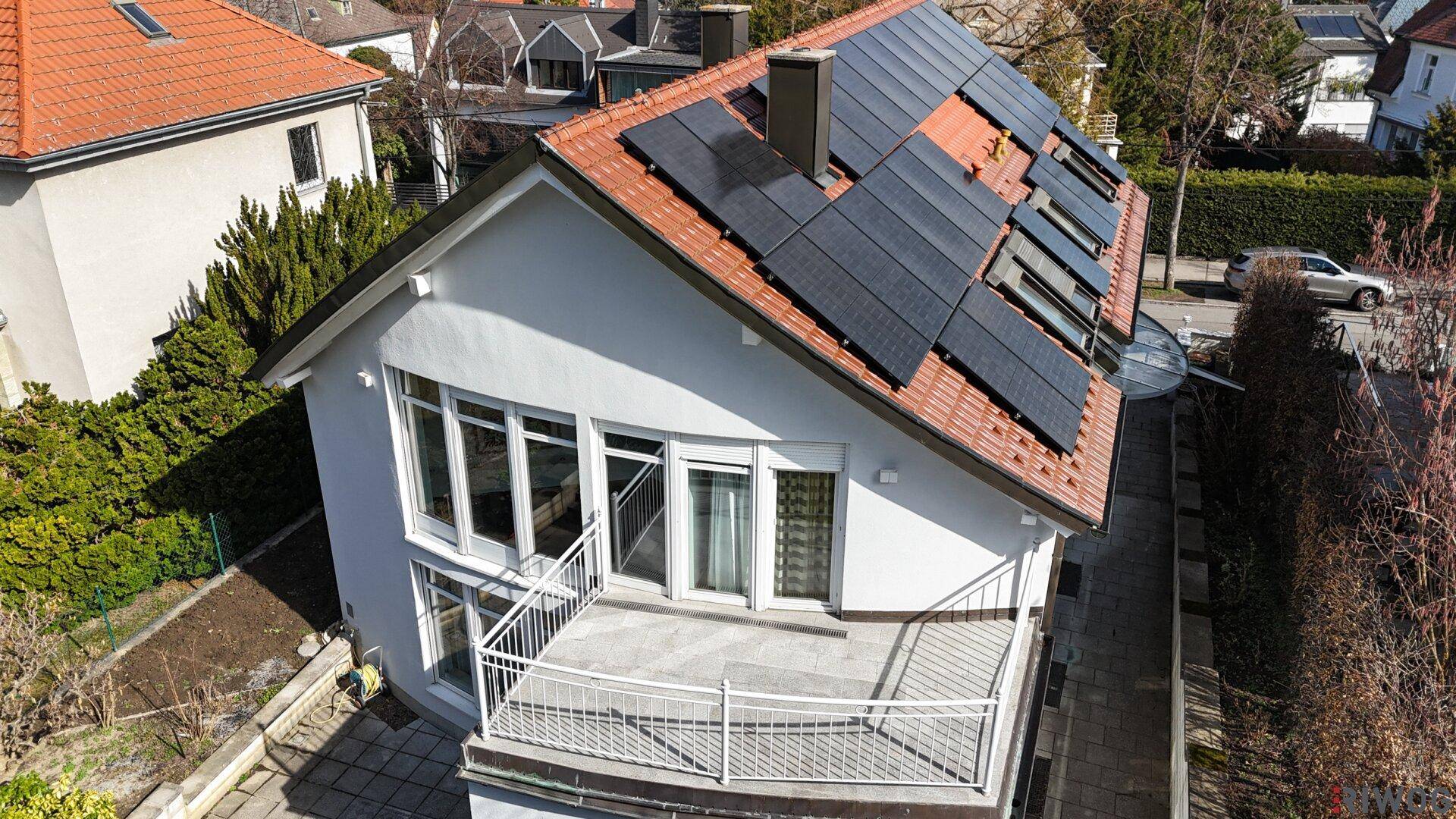 Dachansicht des Hauses mit Solarpaneelen, Terrasse und Blick auf die Umgebung.