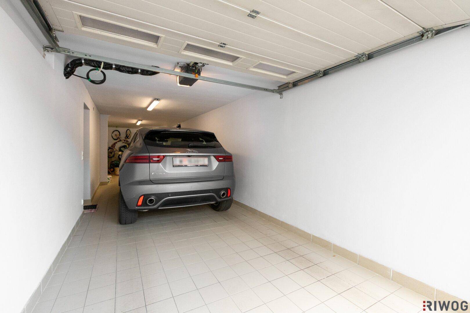Geräumige Garage mit Fliesenboden und Platz für ein Fahrzeug.