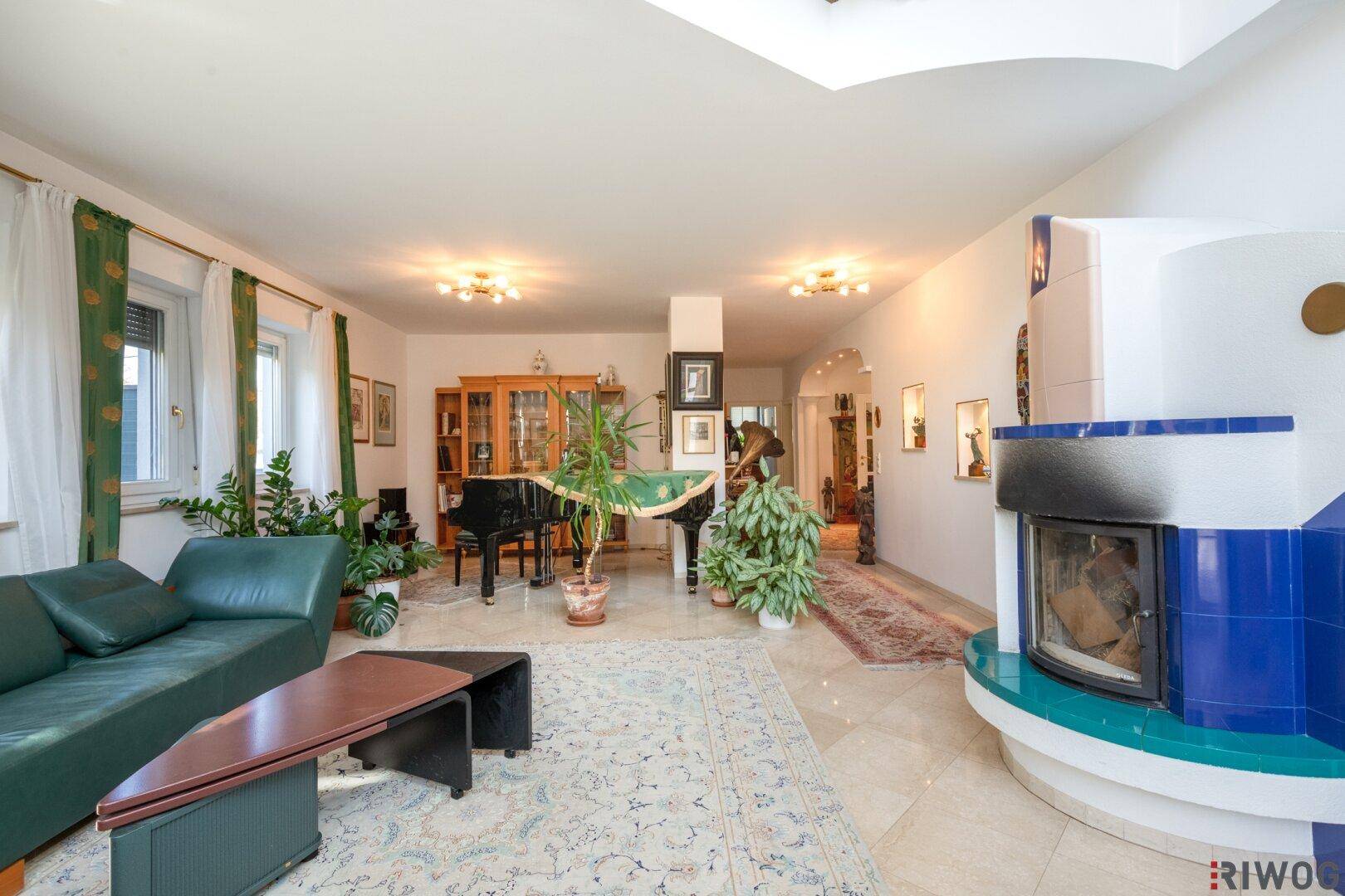 Geräumiges Wohnzimmer mit Kamin, Klavier und hellem Marmorboden.