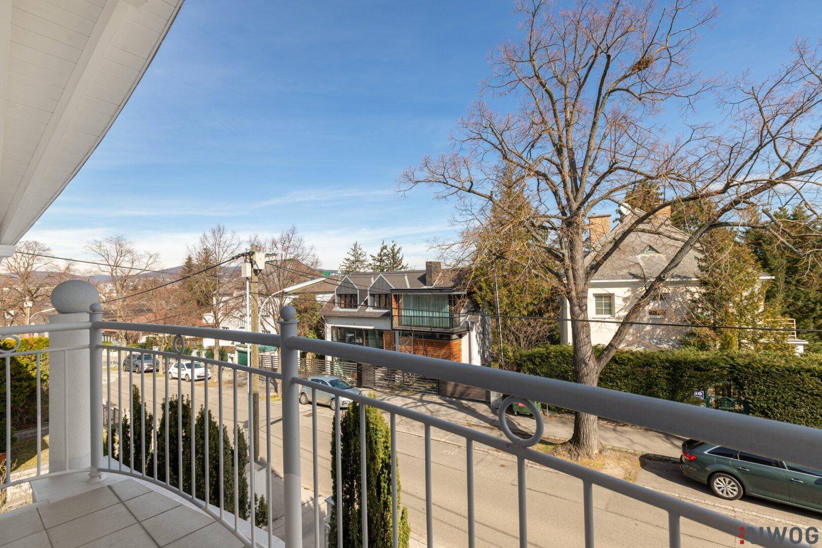 Balkon mit Blick auf die ruhige Wohnstraße und die umliegenden Häuser.