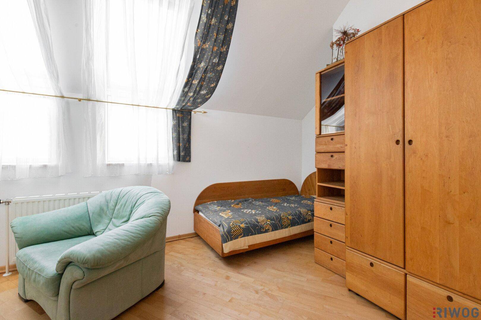 Schlafzimmer im Dachgeschoss mit Holzboden, Kleiderschrank und Tageslicht.