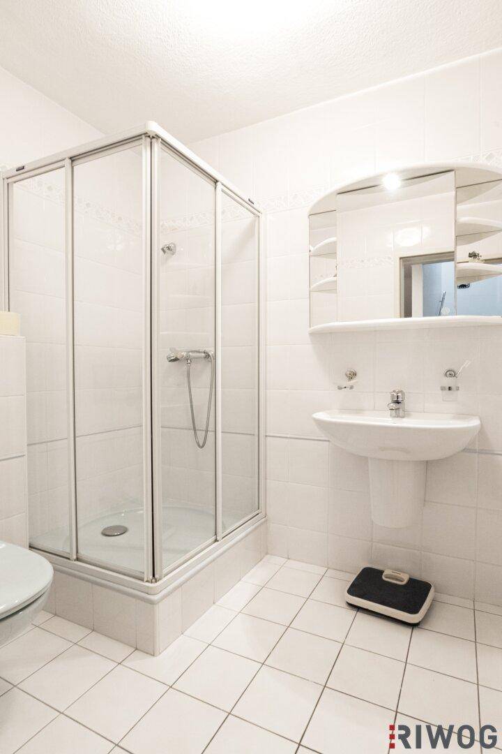 Einfaches Badezimmer im Keller mit Duschkabine und Waschbecken.