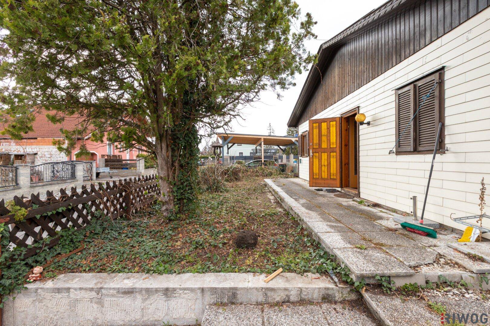 Eingangsbereich des Hauses mit kleiner Rampe und einem gepflegten Vorgarten.