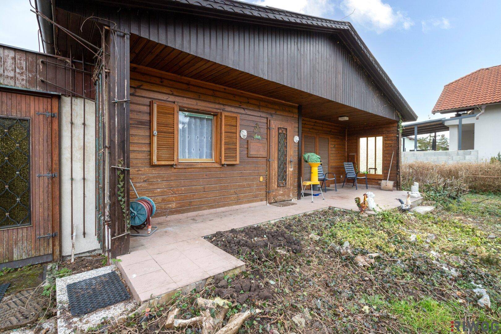 Überdachte Terrasse mit Holzboden und Sitzgelegenheiten, ideal für entspannte Stunden im Freien.