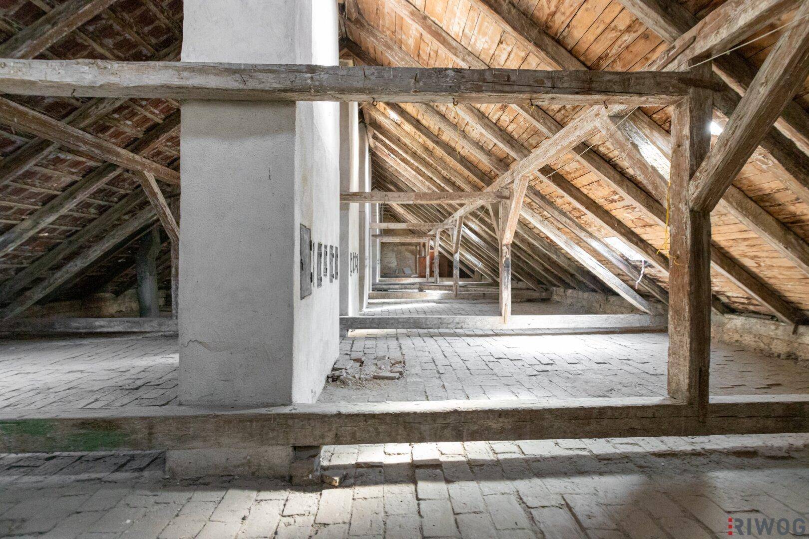 Dachboden mit robustem Holzdachstuhl und Ziegelboden, ideal für einen zukünftigen Ausbau.