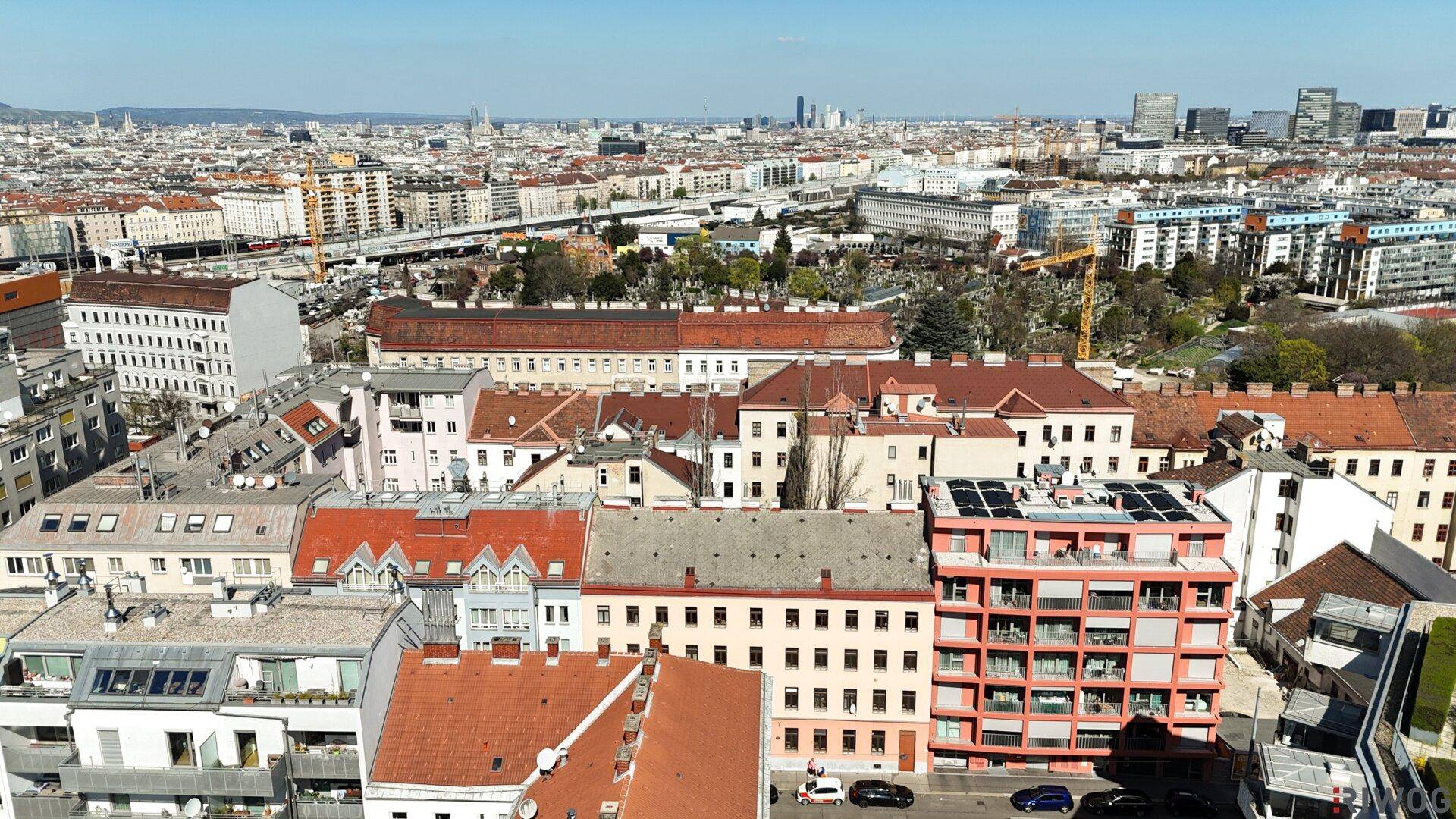 Stadtpanorama mit dicht bebauten Vierteln und modernen Gebäuden unter strahlendem Himmel.