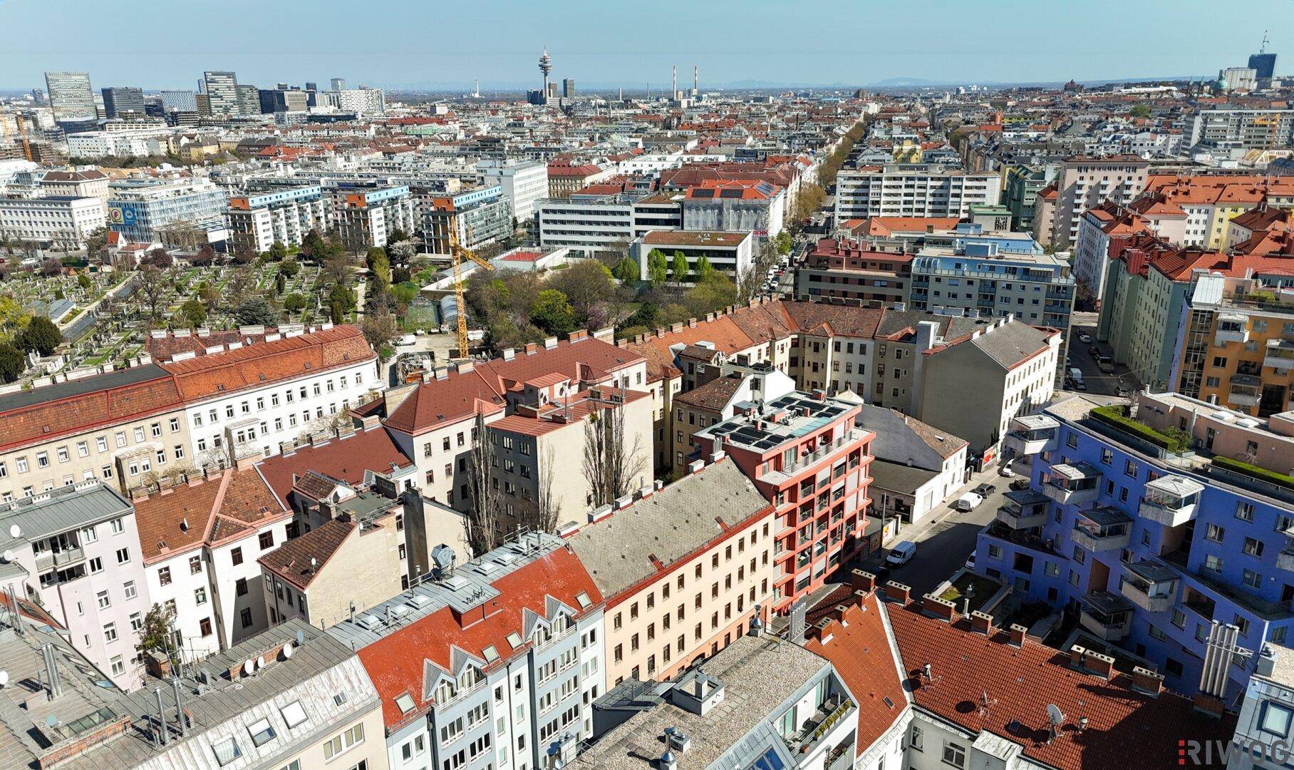 Vogelperspektive auf ein städtisches Viertel mit unterschiedlichen Dächern und Straßen.