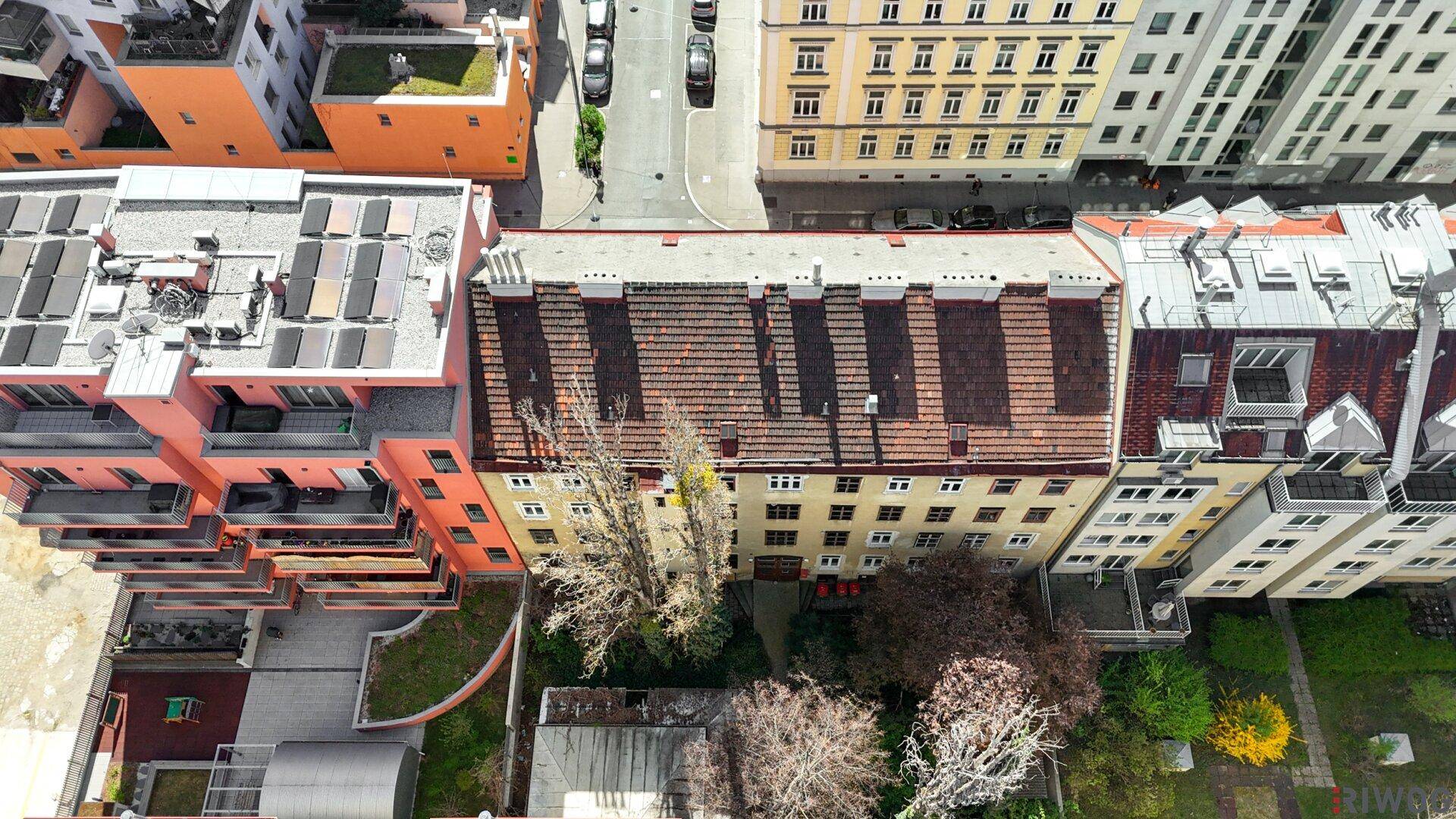 Stadtansicht mit einer langen Straße und verschiedenen Wohngebäuden unter blauem Himmel.