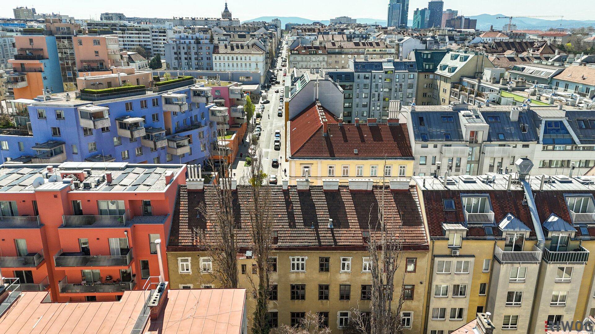 Luftaufnahme eines Wohnhauses mit Garten und umliegenden Gebäuden in urbaner Umgebung.