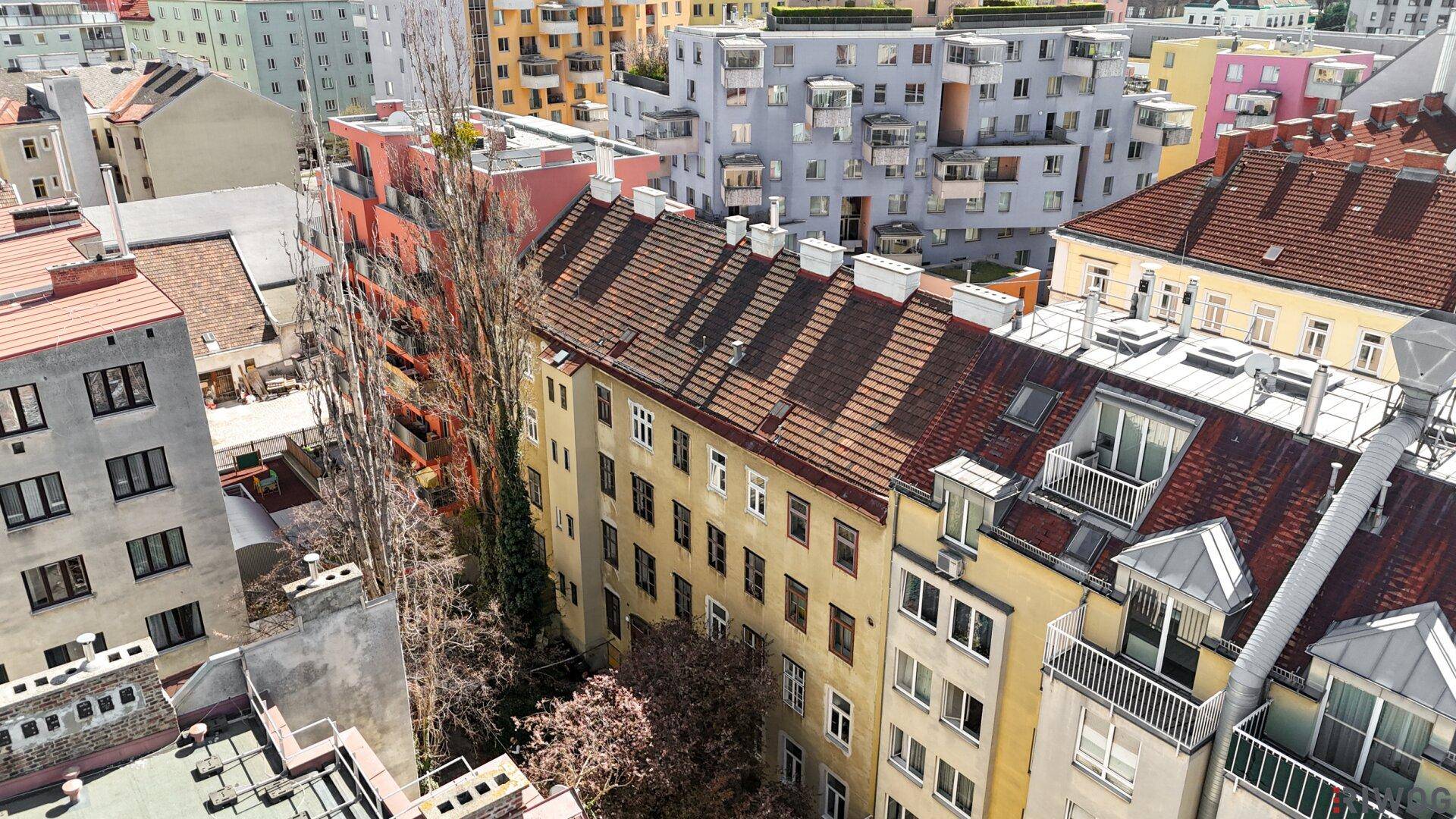 Stadtansicht mit einer Reihe von Gebäuden und einem modernen Wohnkomplex im Vordergrund.