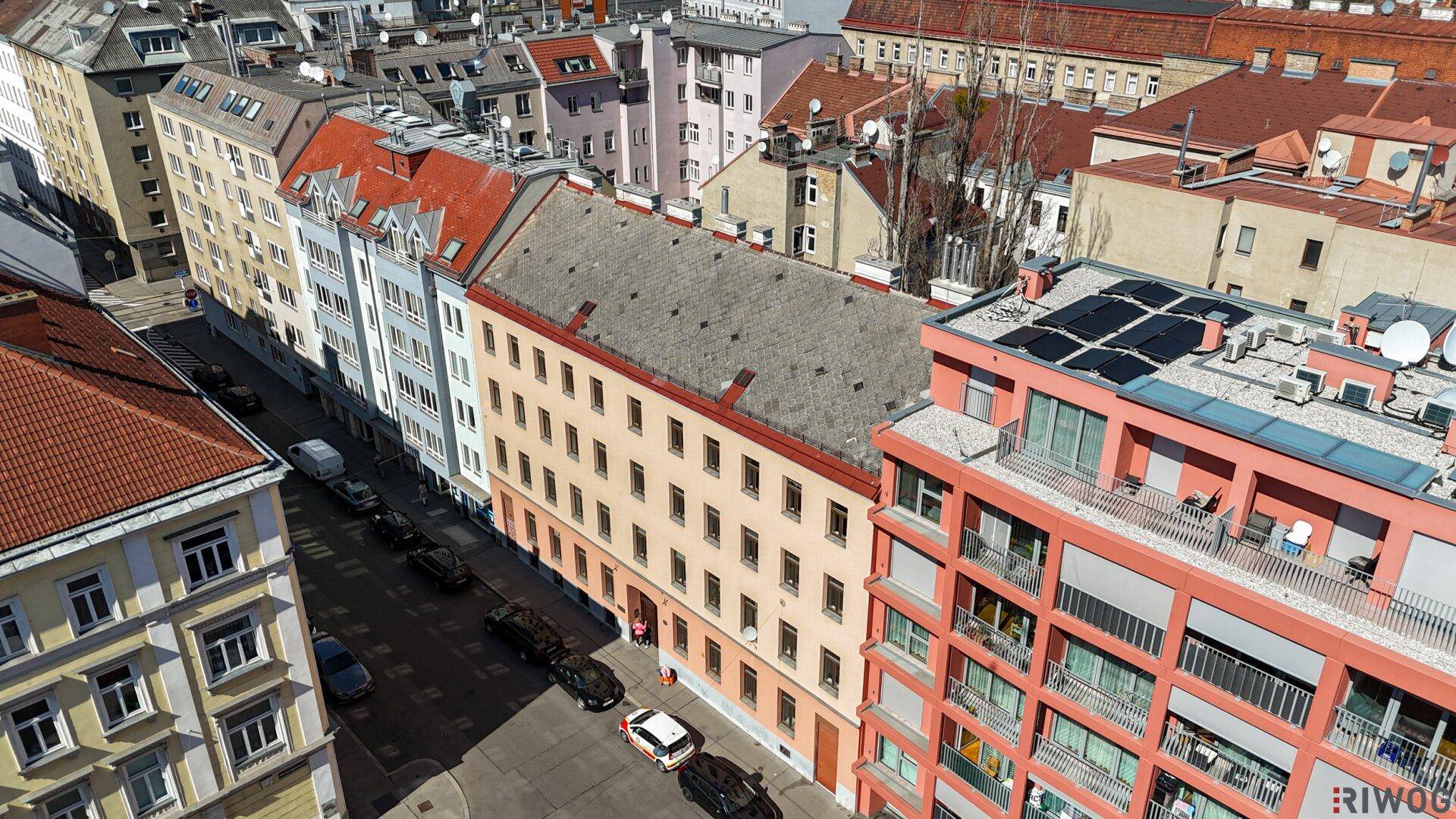 Stadtpanorama mit einer Reihe von Gebäuden und einem modernen Wohnkomplex unter blauem Himmel.