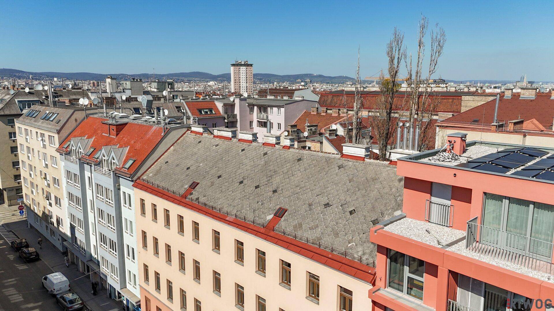 Luftaufnahme eines Wohnhauses mit klassischer Fassade und umliegenden Gebäuden in der Stadt.