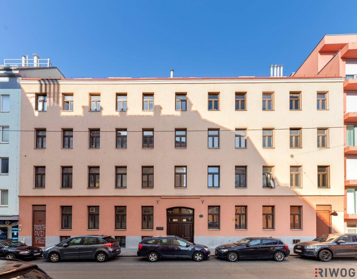 Historisches Mehrfamilienhaus mit klassischer Fassade und vielen Fenstern in urbaner Umgebung.