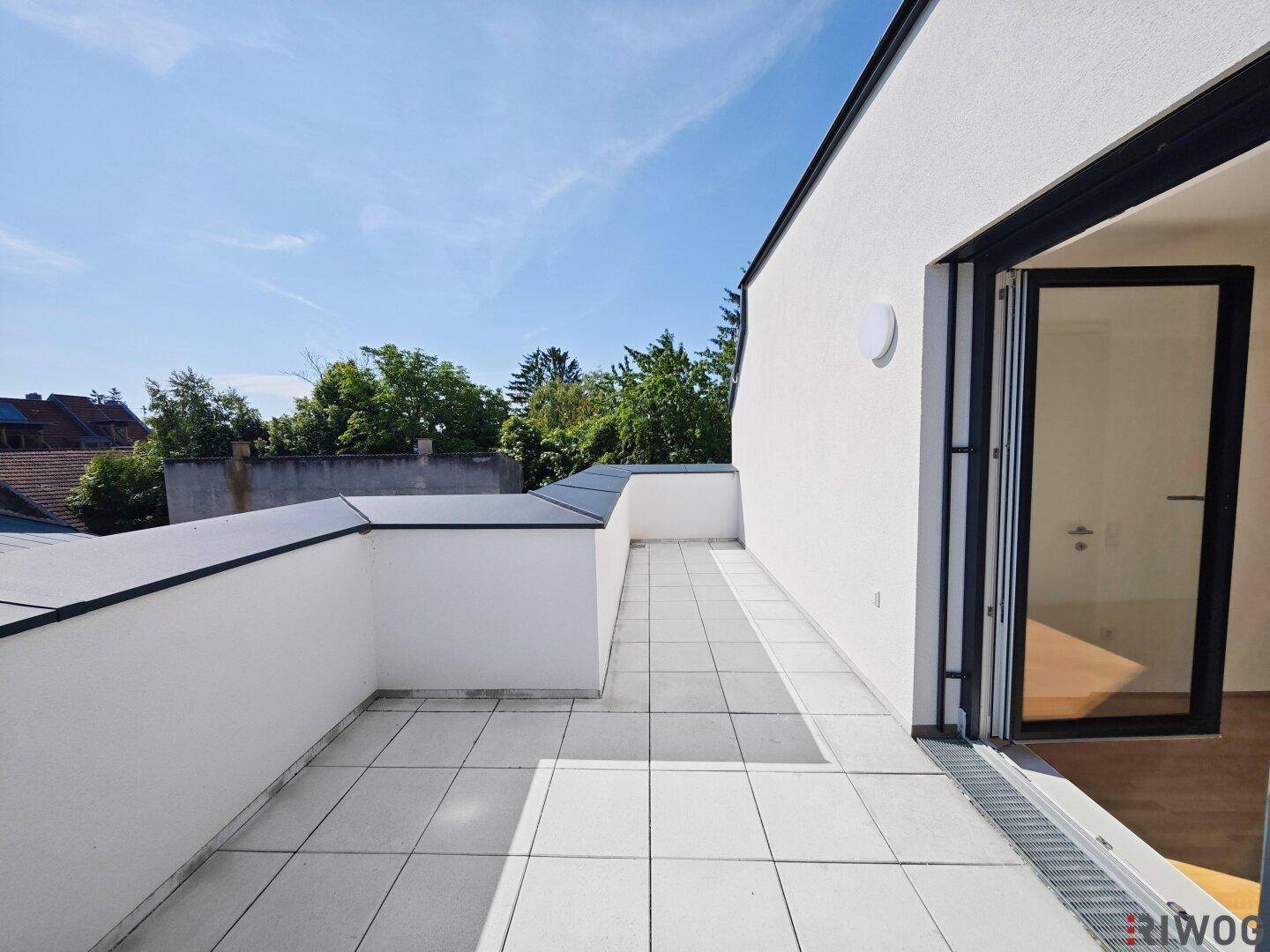 Große Dachterrasse mit Fliesenboden und weitem Blick, ideal für Entspannung im Freien.