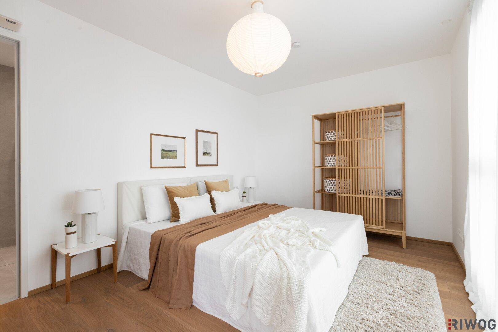 Helles Schlafzimmer mit Holzboden, Doppelbett und modernem Holzregal.