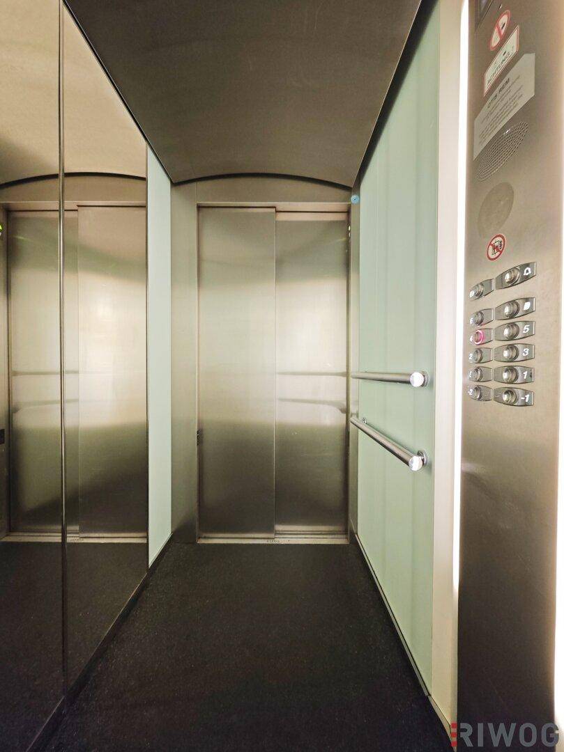 Moderner Aufzug mit Edelstahloberflächen und Spiegelfront, bietet bequemen Zugang zu allen Etagen.