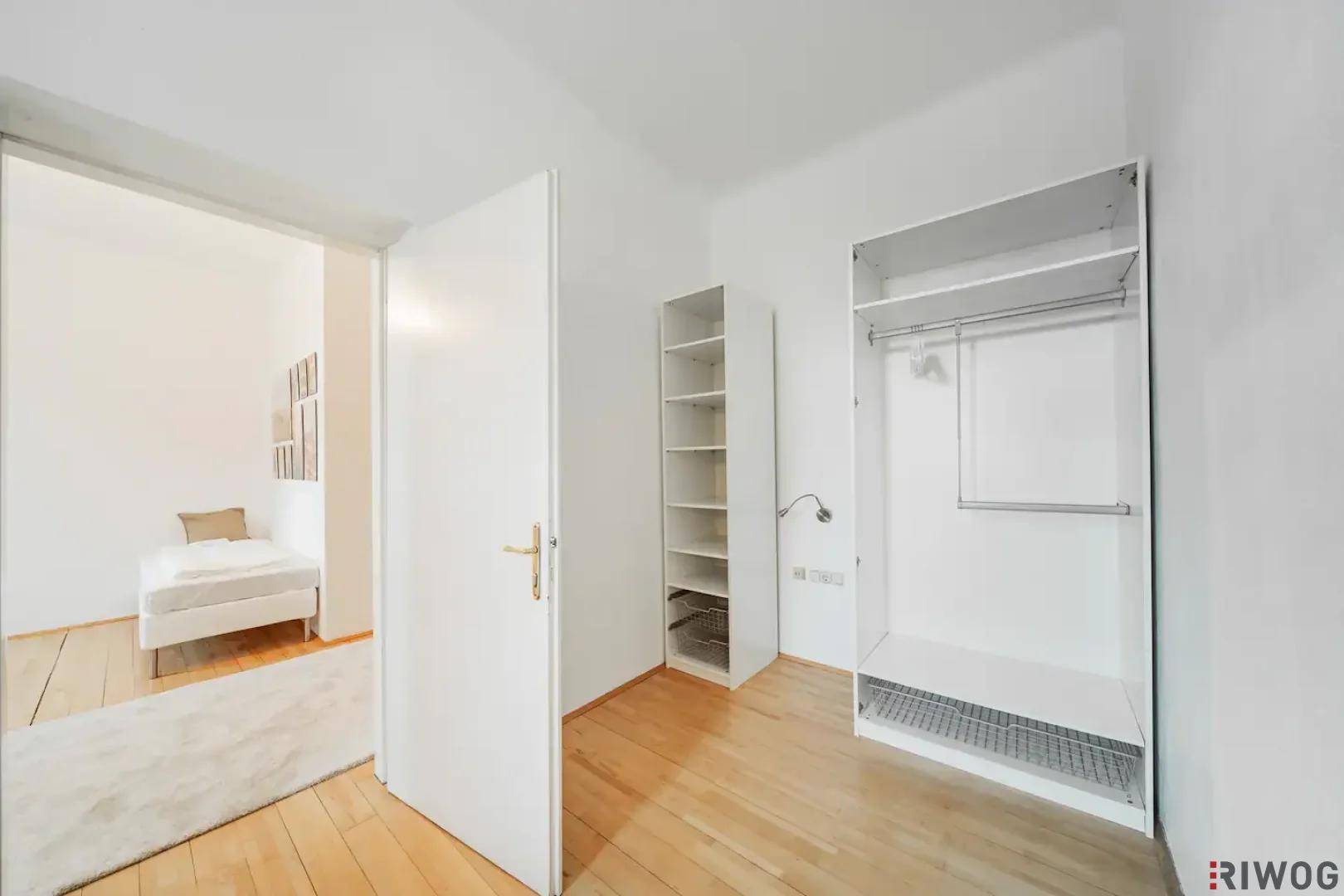 Flur mit offenem Kleiderschrank und Blick in ein angrenzendes Schlafzimmer.