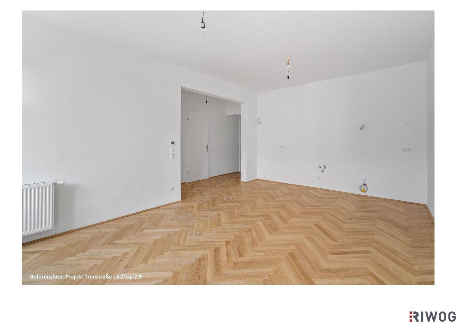 Leerer Raum mit Fischgrätparkett und weißen Wänden, vorbereitet für weitere Installationen.