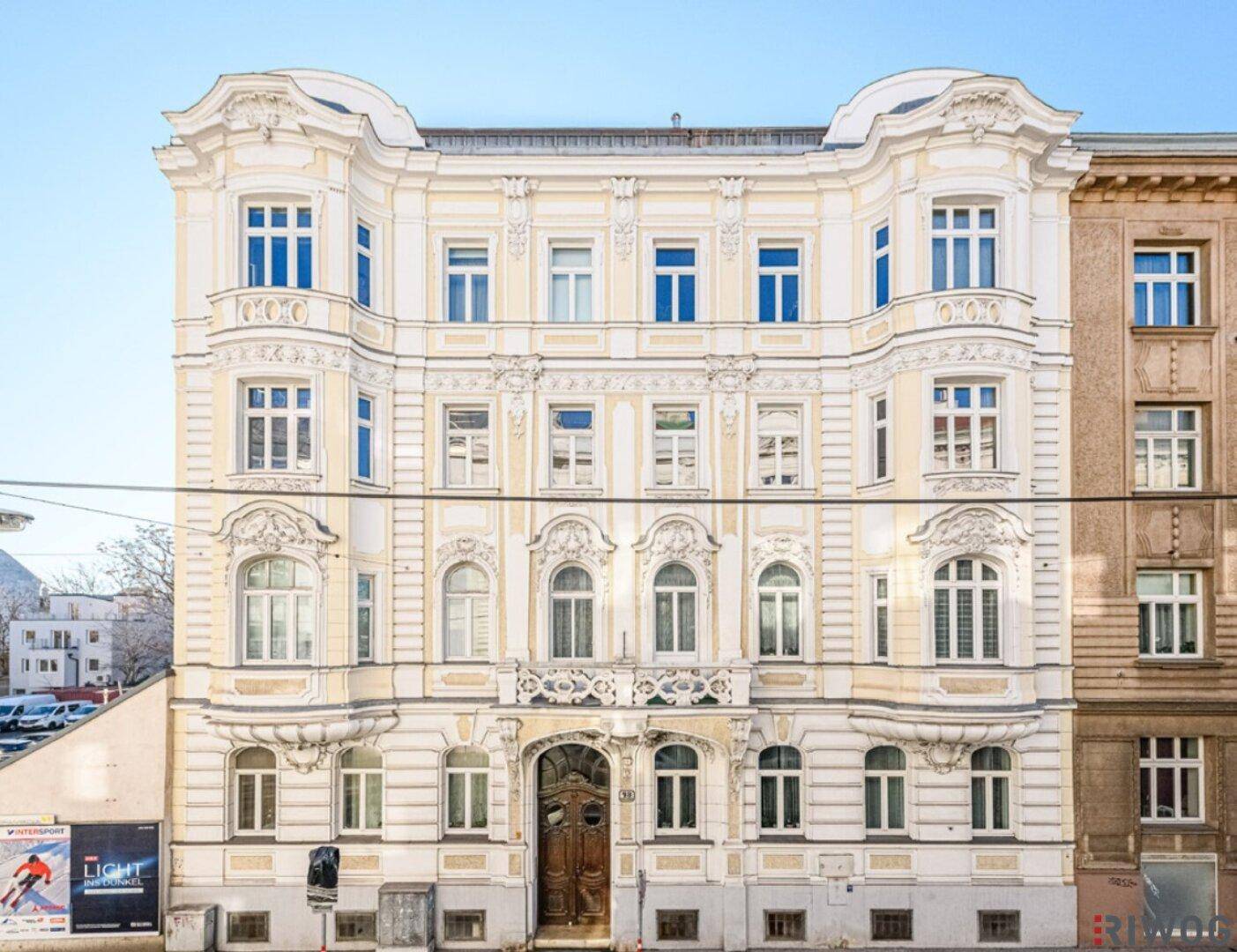 Prunkvolle Fassade eines historischen Gebäudes mit reich verzierten Fenstern und Balkonen.
