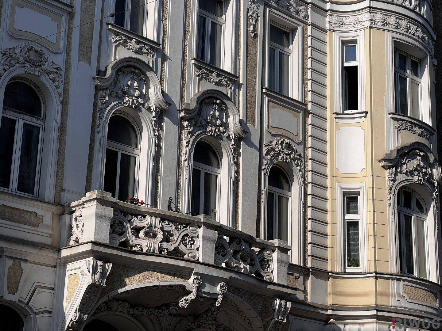 Detailansicht eines verzierten Balkons an einer historischen Fassade mit kunstvollen Geländern.