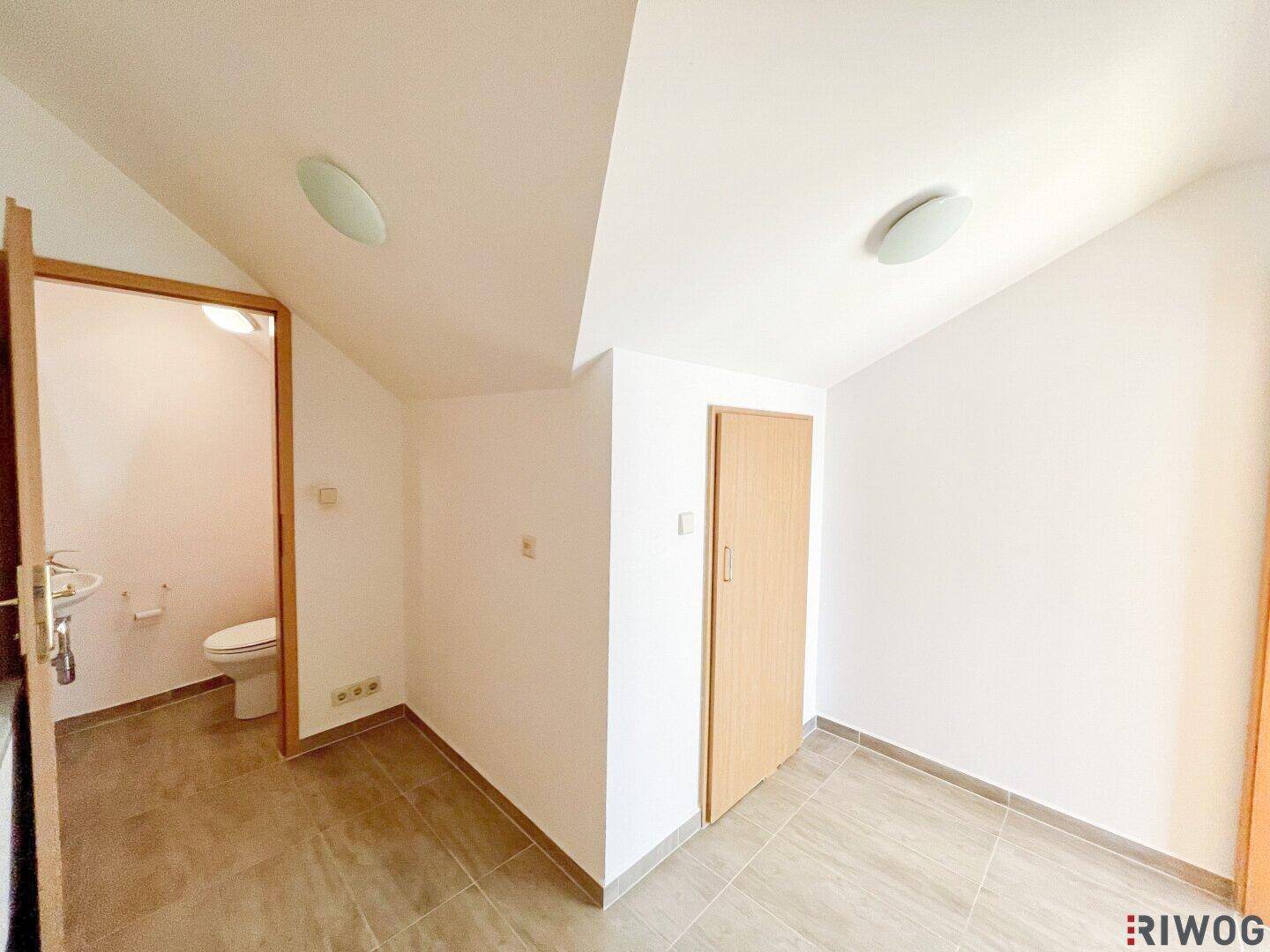 Zwei kleine Räume, einer davon ein WC, beide mit Fliesenboden und einfacher Ausstattung.