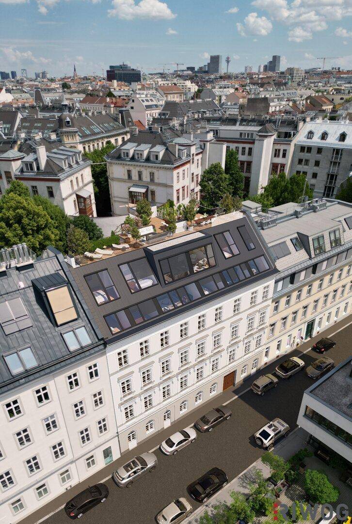 Luftaufnahme des Gebäudes mit modernem Dachausbau, umgeben von der städtischen Skyline und belebten Straßen.