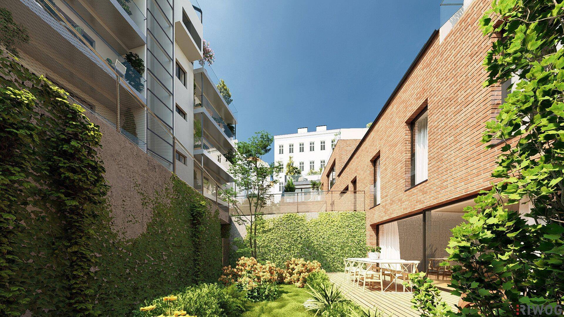 Heller Gartenbereich mit Holzterrasse, Essplatz und blühenden Pflanzen, umgeben von grünen Wänden.