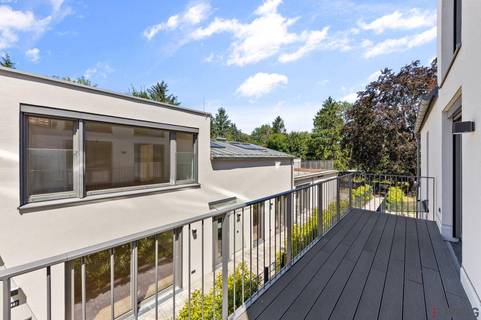 Geräumiger Balkon mit Holzdielen und Blick ins Grüne, ideal zum Entspannen.