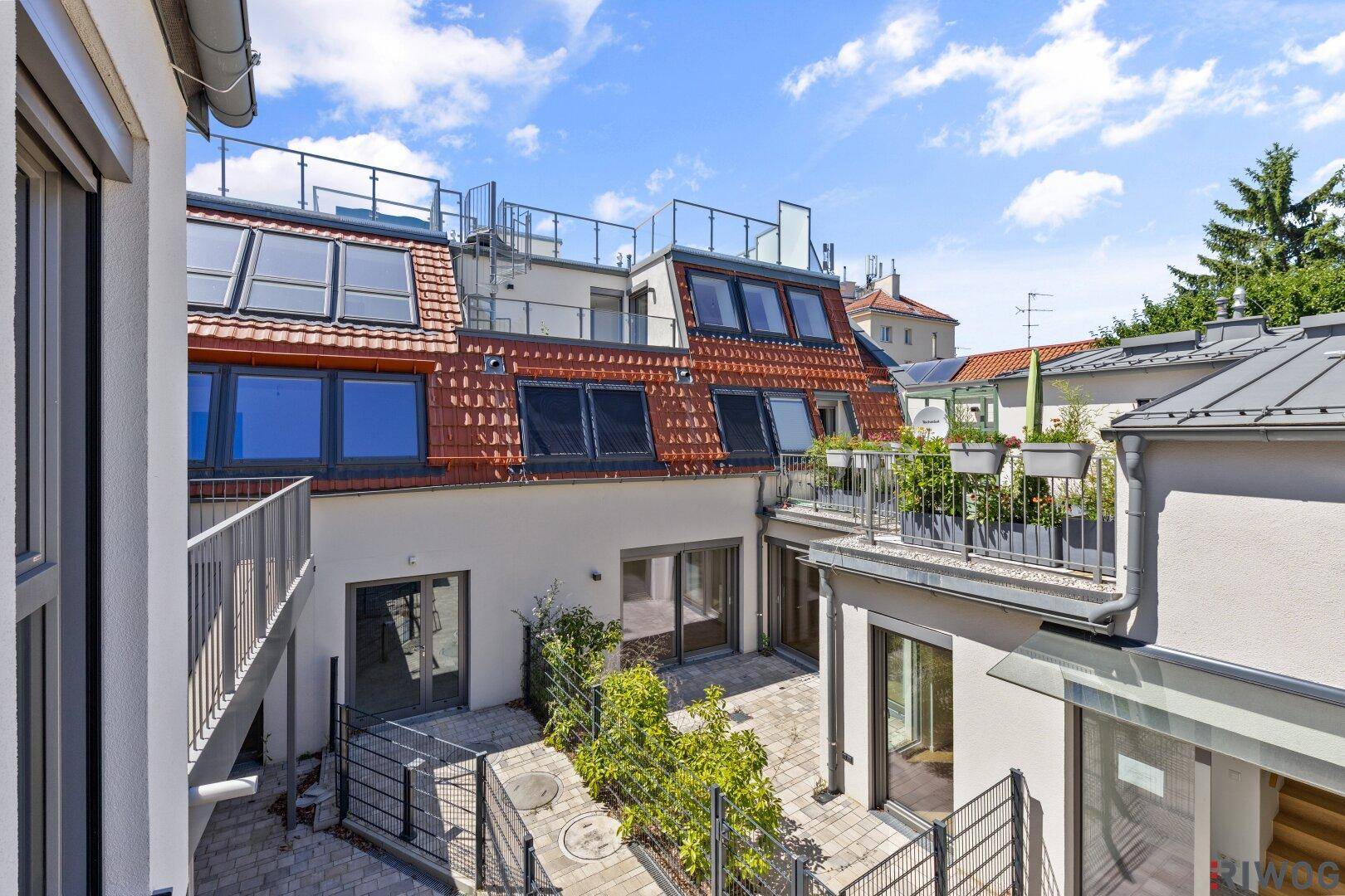Blick auf moderne Wohngebäude mit Dachterrassen und begrünten Außenbereichen.