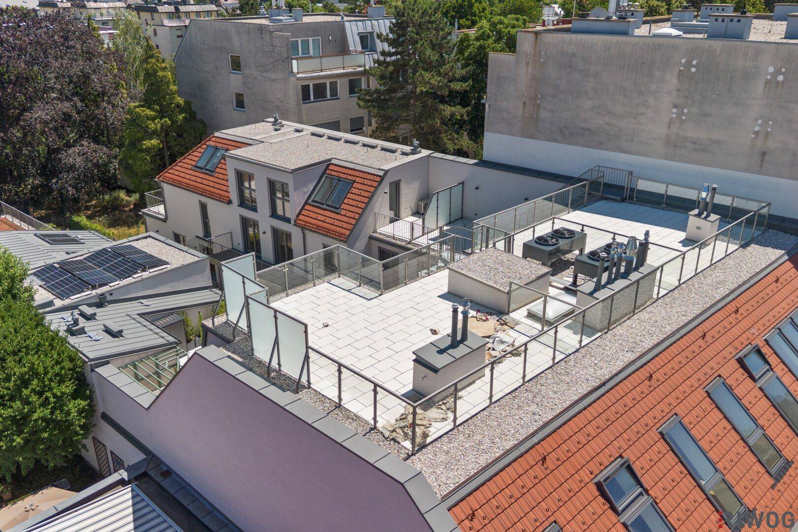 Große Dachterrasse mit Sitzgelegenheiten und Blick auf die umliegenden Gebäude.