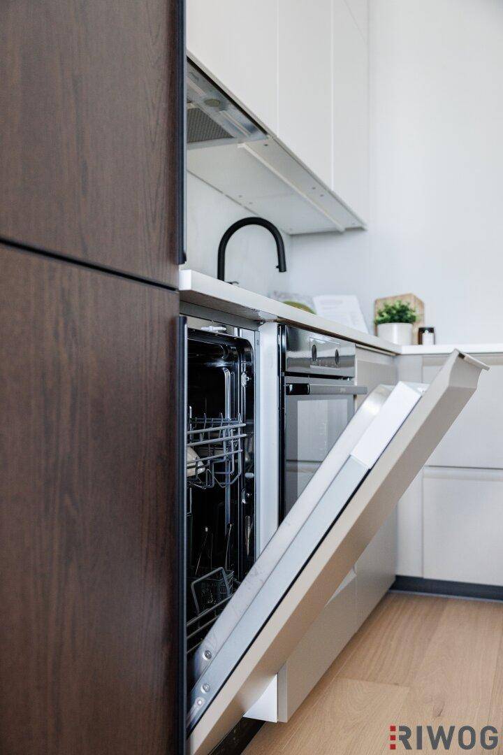 Moderne Küche mit geöffnetem Geschirrspüler und integrierten Küchenschränken.