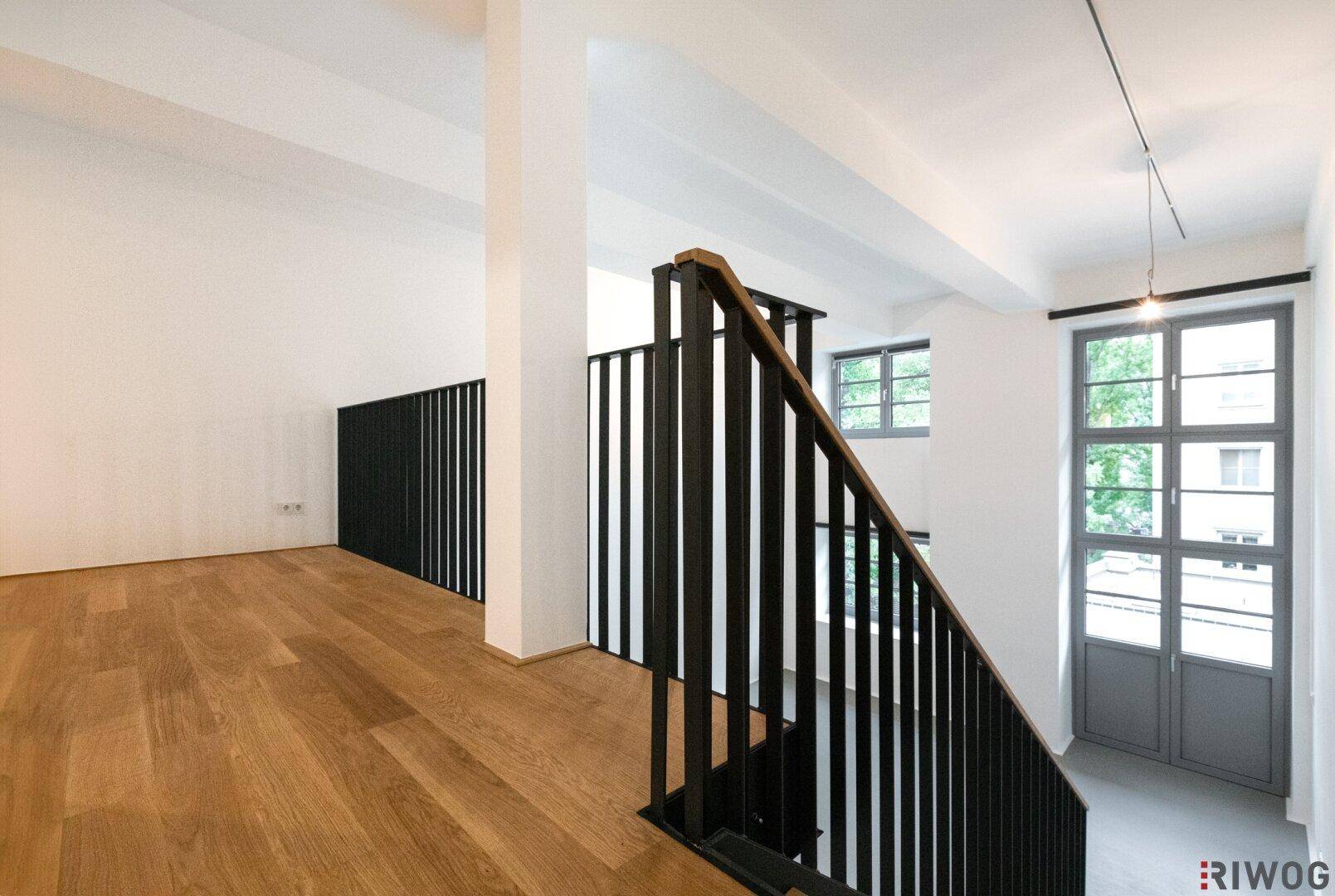 Obere Galerie mit Holzfußboden und Blick auf den unteren Wohnbereich.