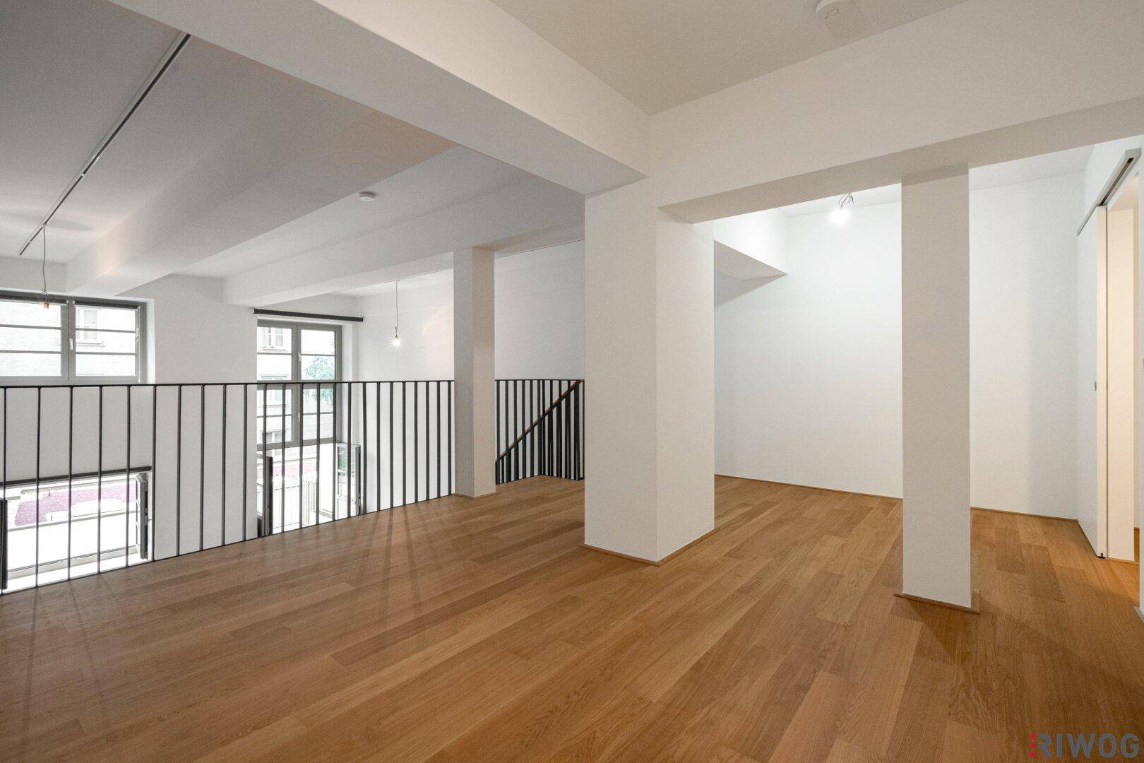 Geräumiger Galeriebereich mit Holzfußboden und offener Gestaltung.