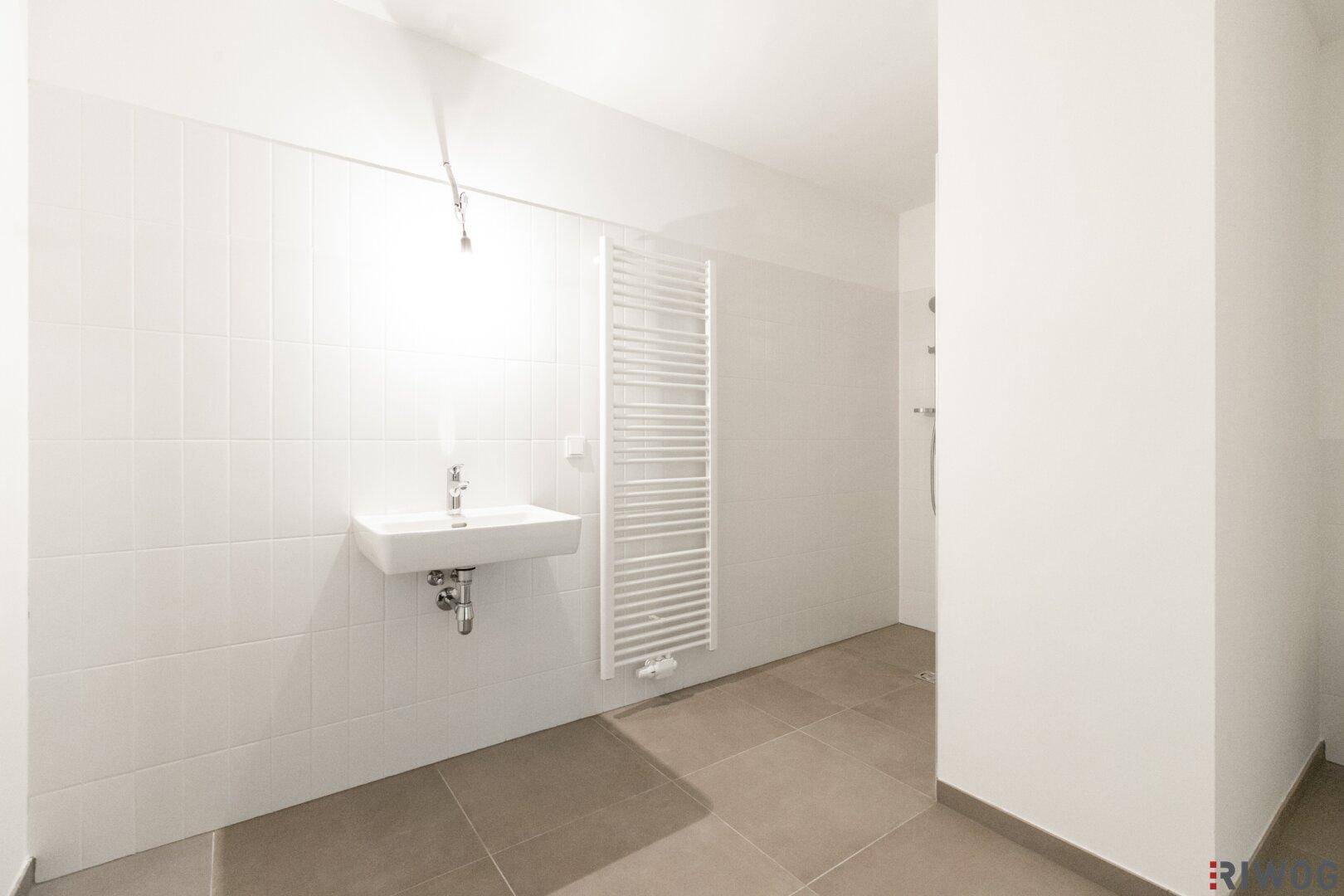 Helles Badezimmer mit modernem Waschbecken und praktischem Handtuchheizkörper.