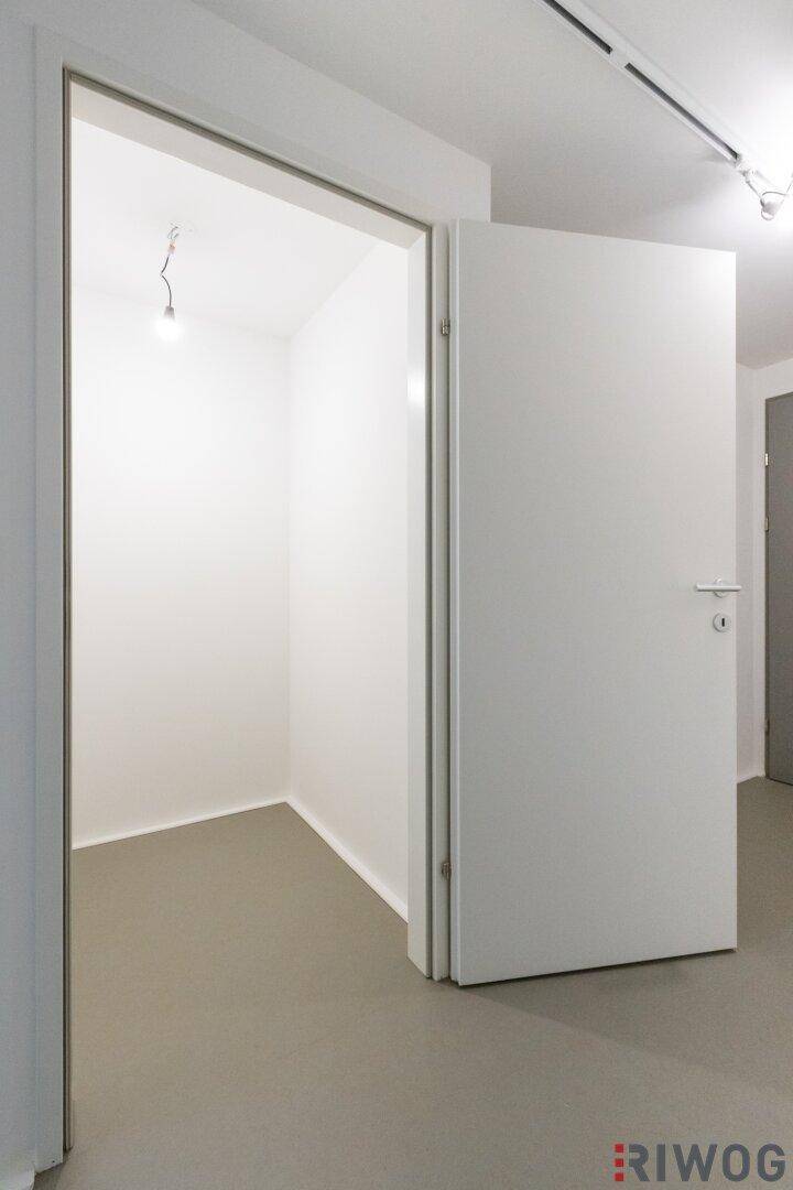 Kleiner, heller Raum mit Tür, nutzbar als Abstellraum oder begehbarer Kleiderschrank.