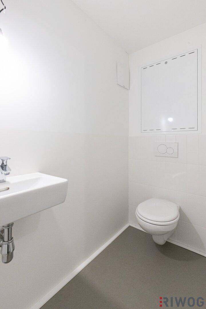Modernes Gäste-WC mit Hänge-WC und kleinem Waschbecken.