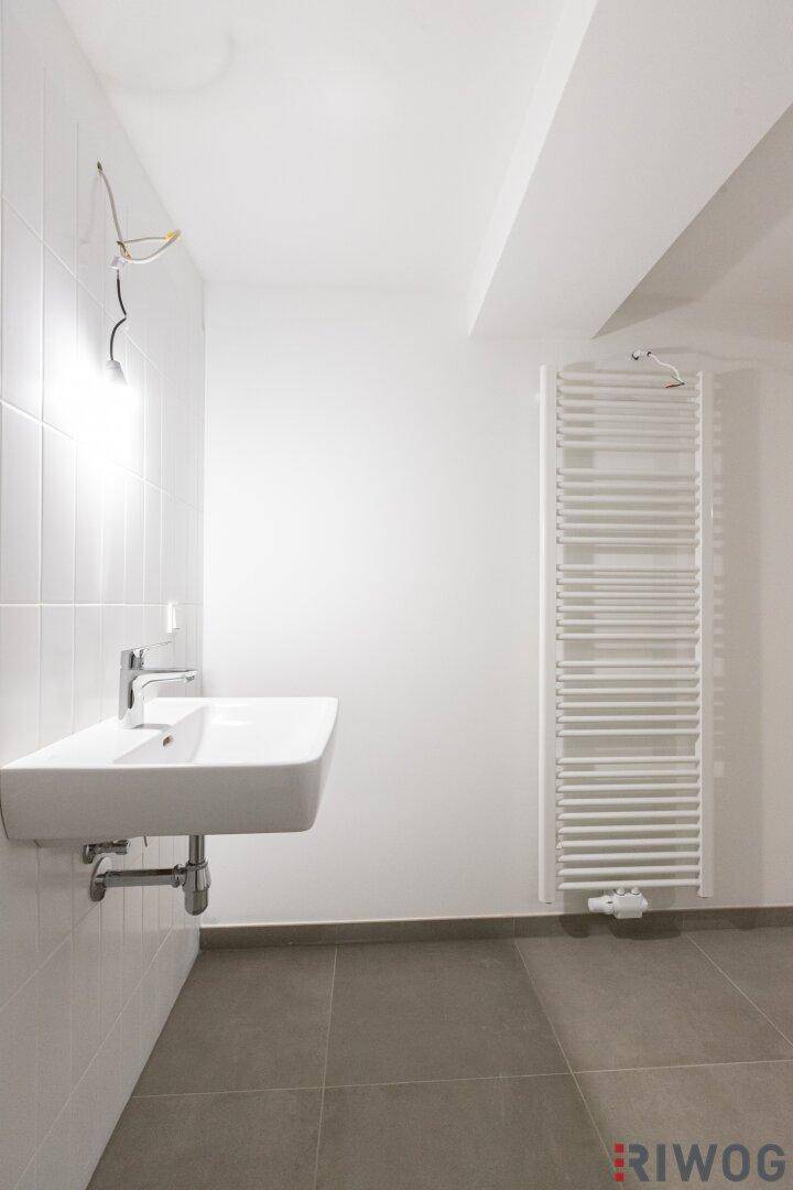 Modernes Badezimmer mit Waschbecken und beheiztem Handtuchhalter.
