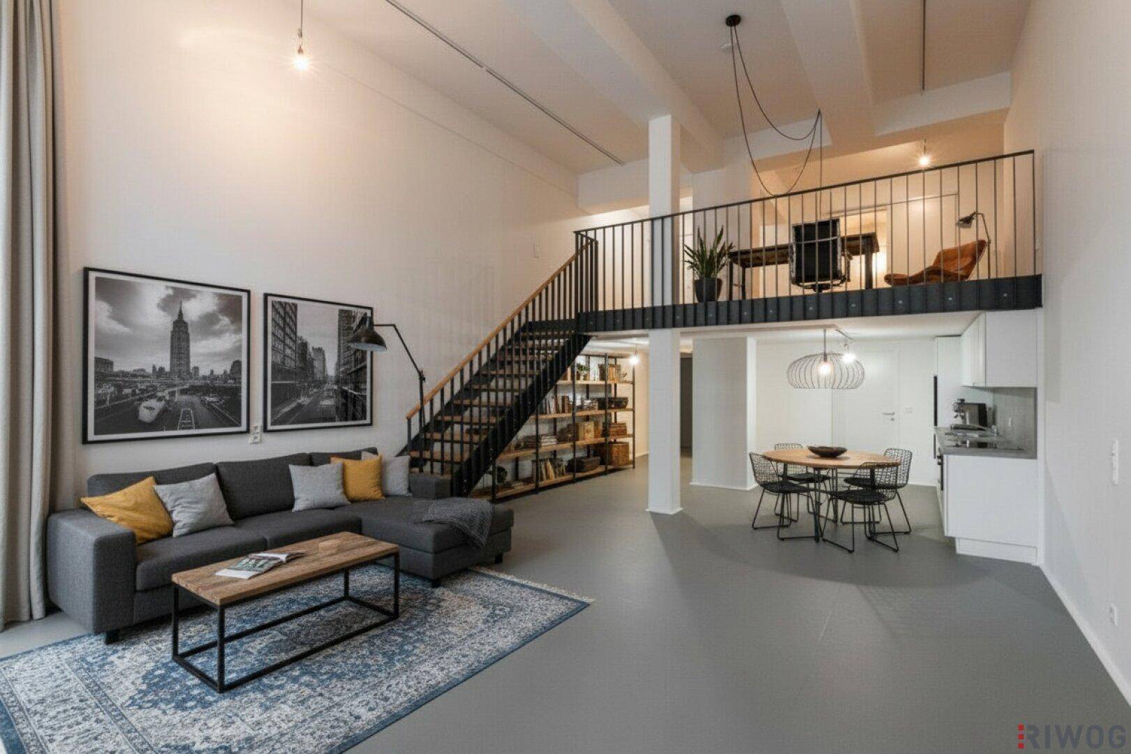 Stilvoller Loft-Wohnbereich mit Sofa, Esstisch, Galerie und moderner Einrichtung.