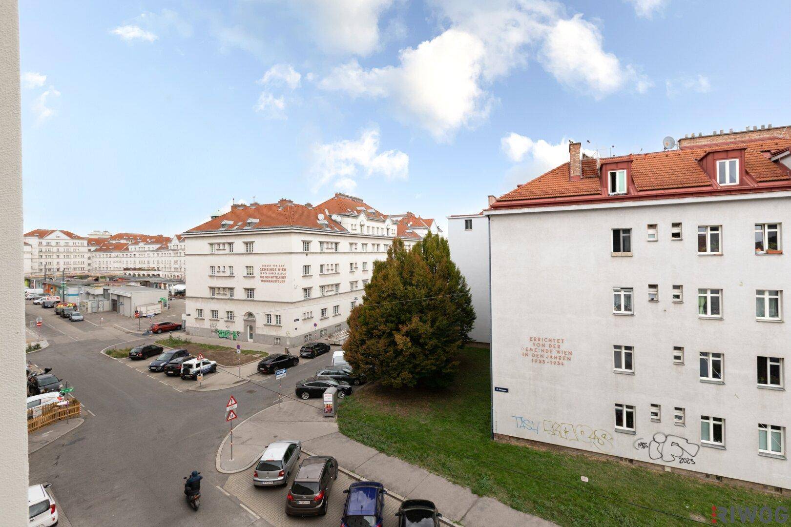 Blick auf die umliegende Wohngegend mit Gebäuden, Bäumen und parkenden Autos.
