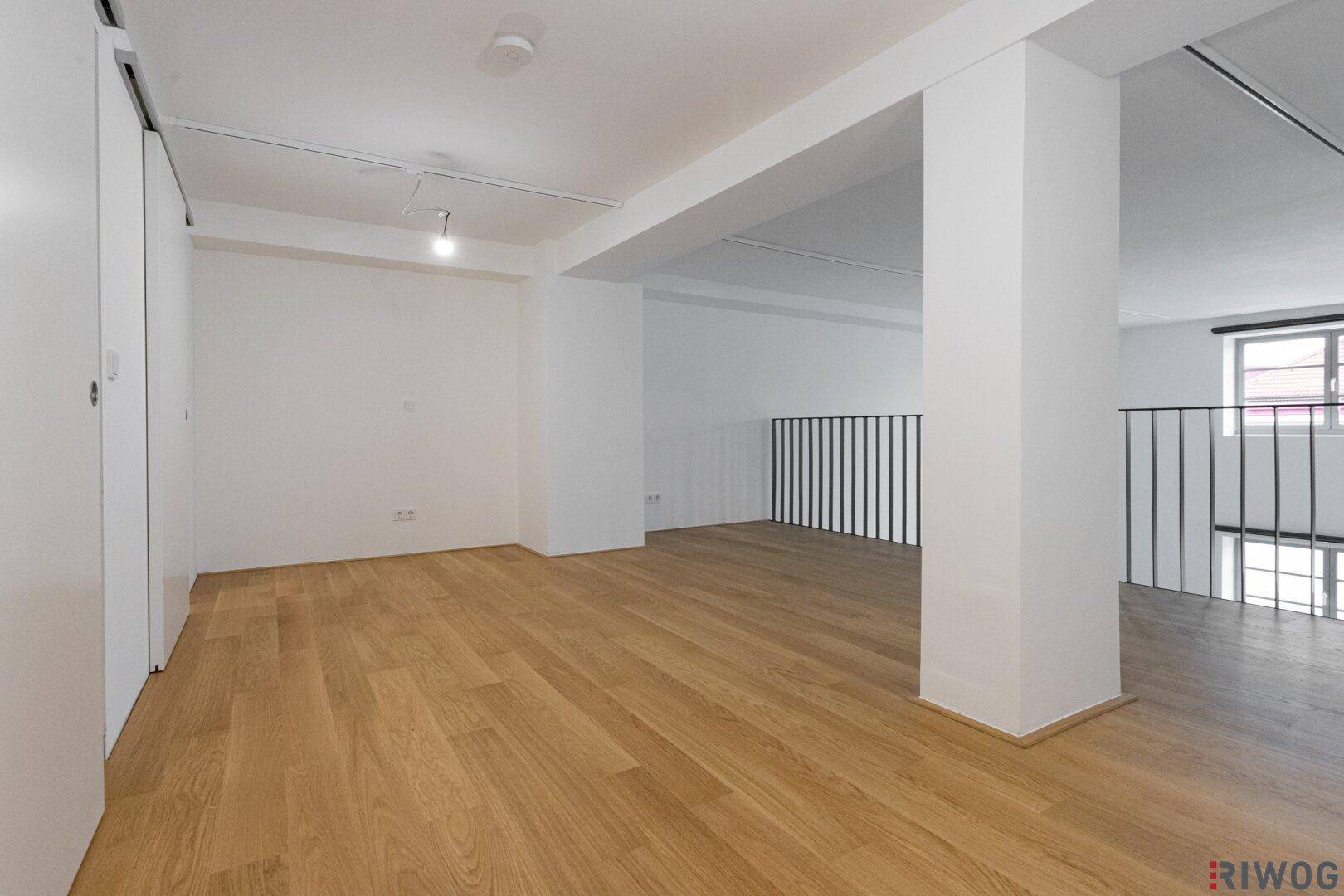 Offene Galerie mit Eichenparkettboden und moderner Schiebetür.