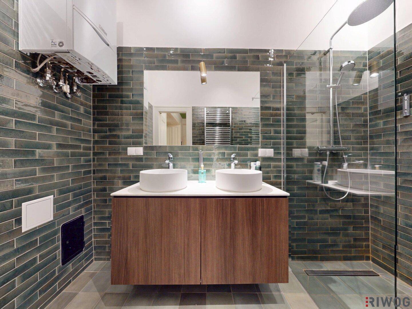 Helles Badezimmer mit zwei Waschbecken, begehbarer Dusche und modernen Wandfliesen.