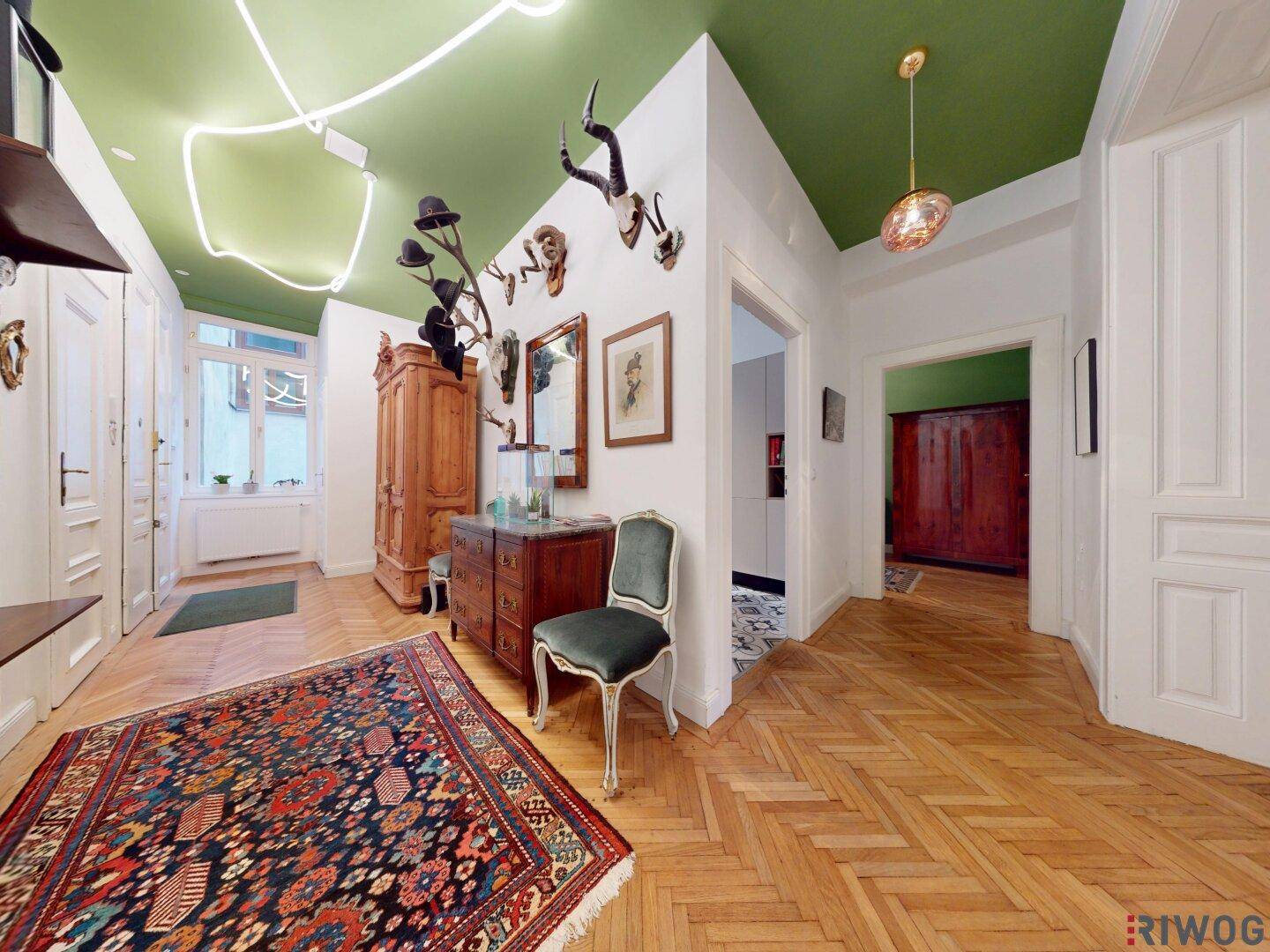 Geräumiger Flur mit Parkettboden, grüner Decke und traditionellen Dekorationen.