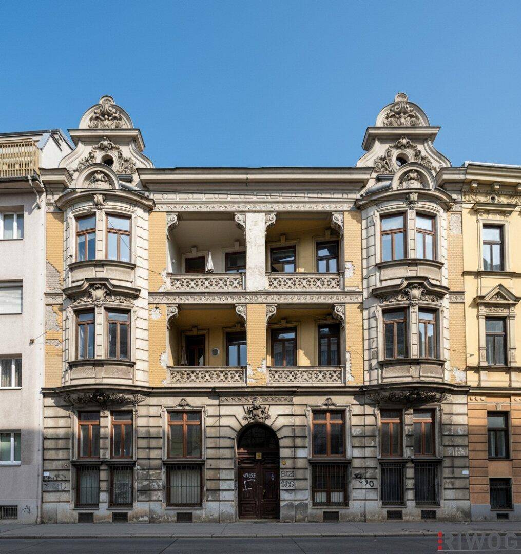 Historische Fassade eines Altbaus mit reich verzierten Details und Balkonen.