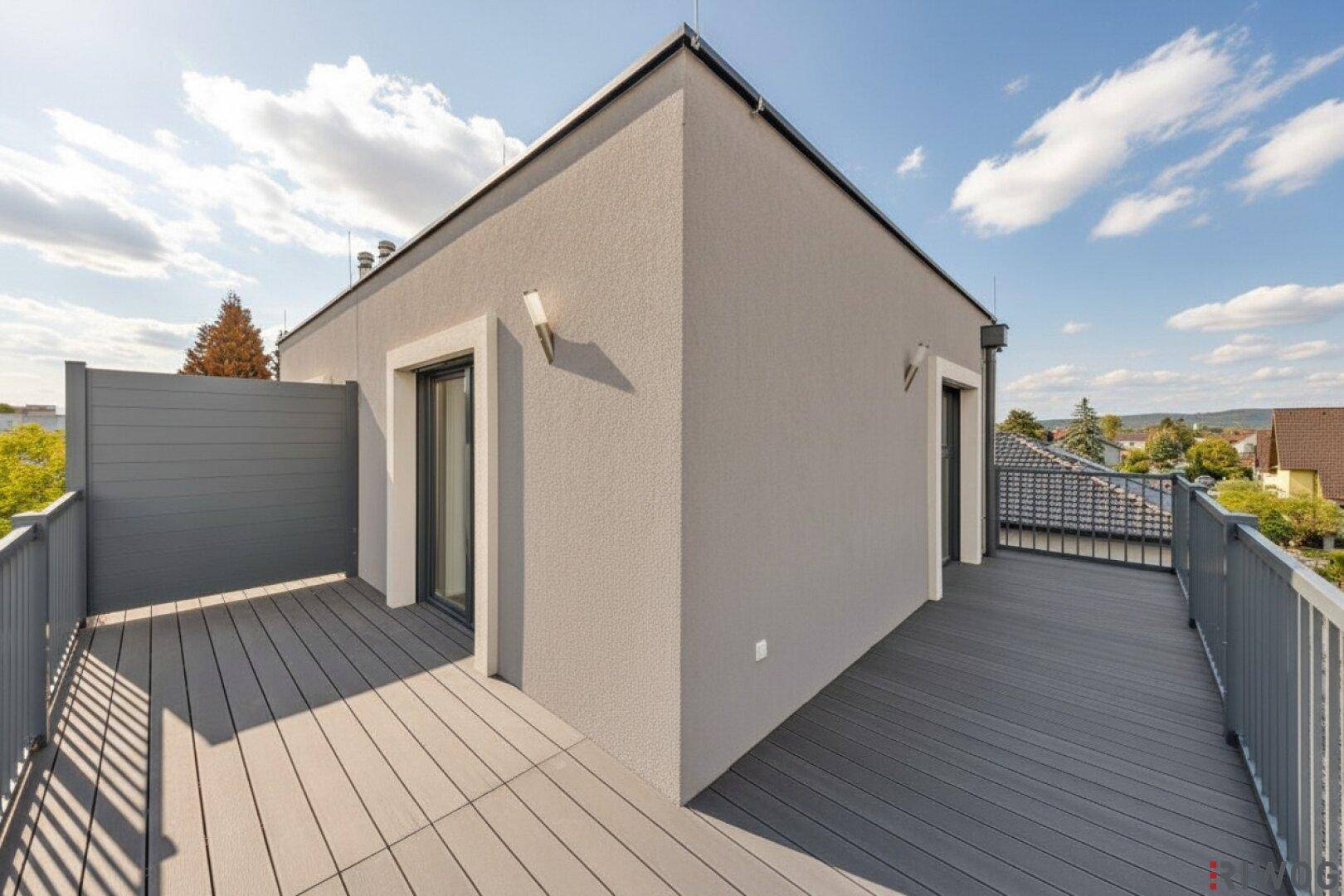 Geräumige Dachterrasse mit modernem Bodenbelag und weitem Ausblick über die Umgebung.