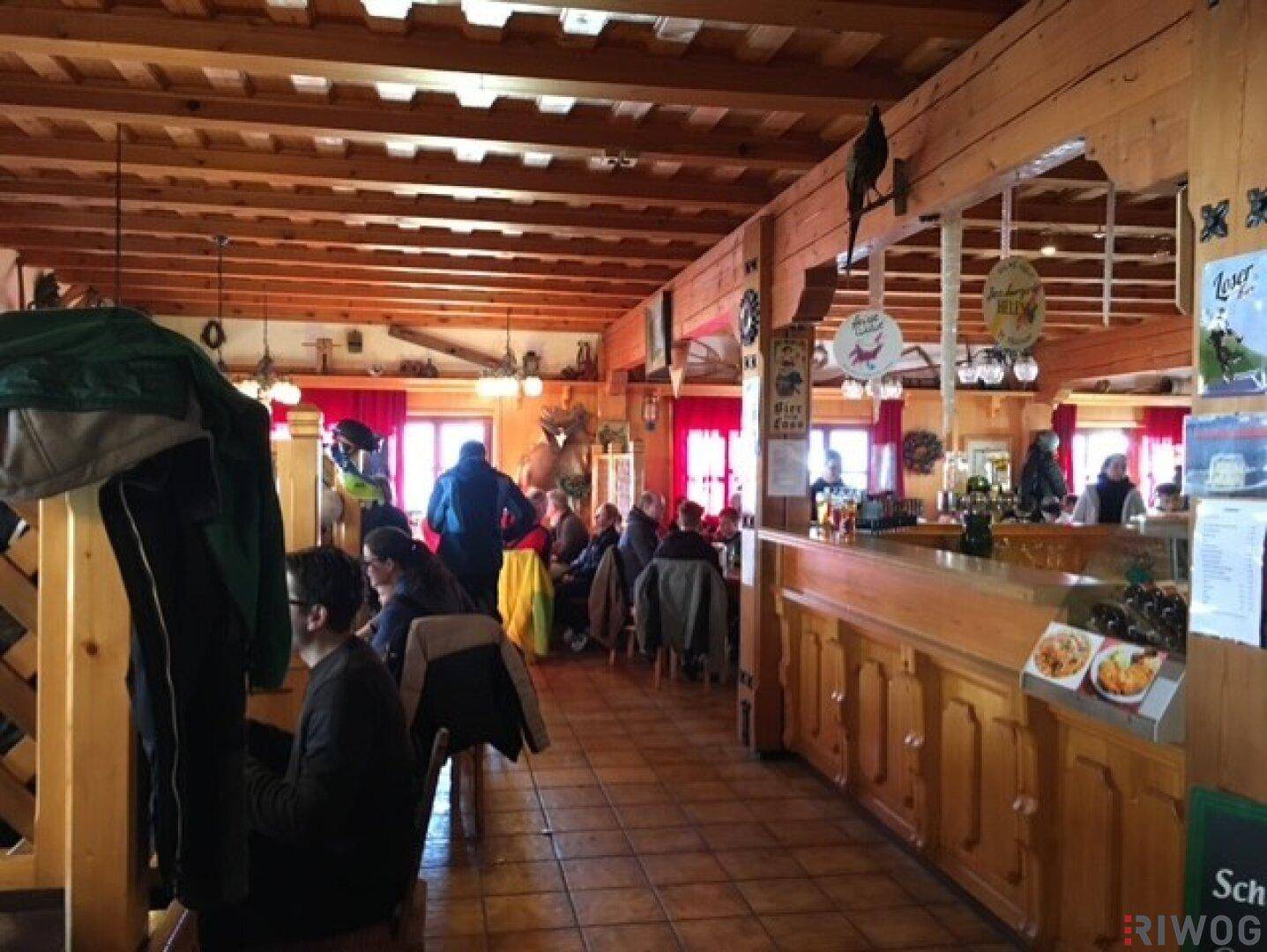 Belebtes Restaurant mit Gästen, Holzeinrichtung und traditionellem Ambiente.