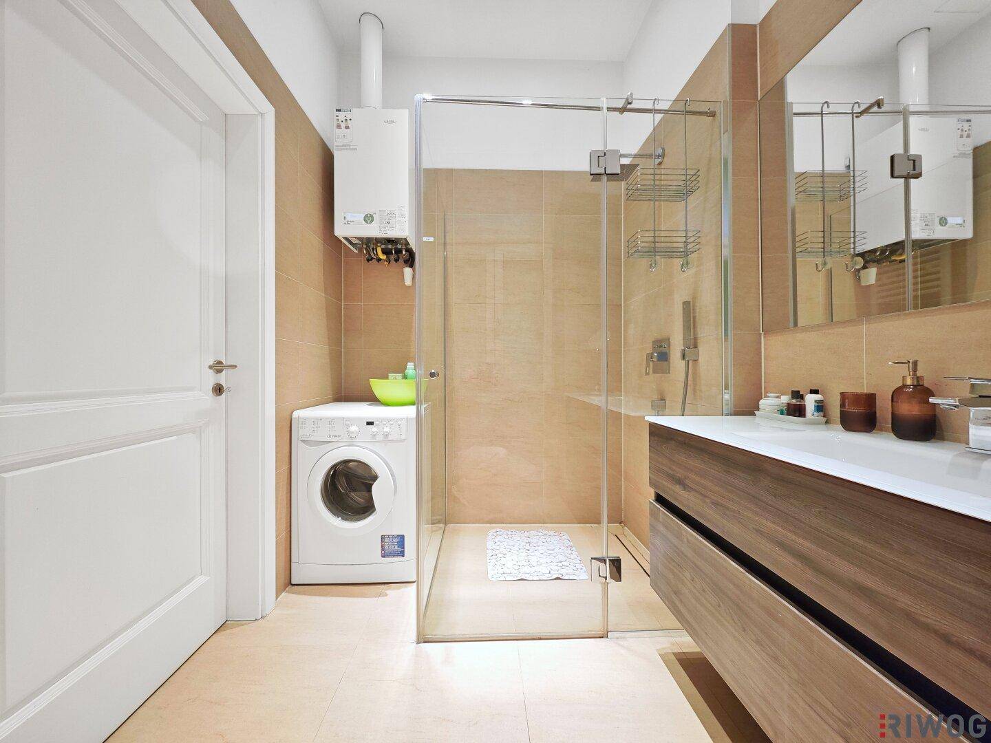 Modernes Badezimmer mit begehbarer Dusche, Waschmaschine und Holzwaschtisch.
