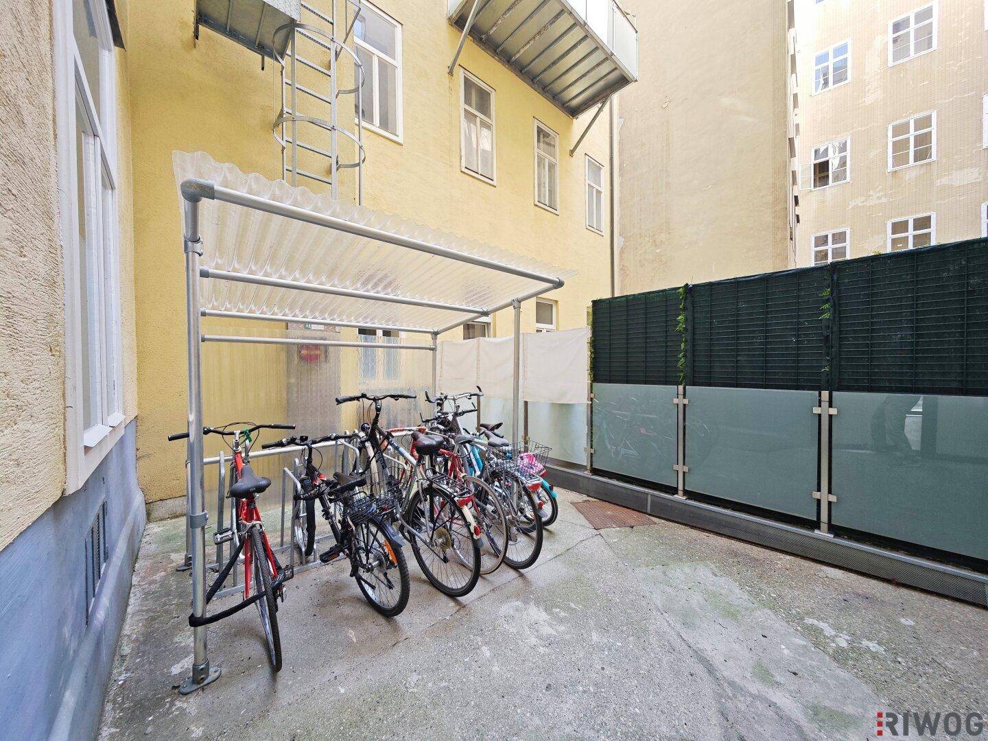 Innenhof mit überdachtem Fahrradabstellplatz und Gebäudefassaden.